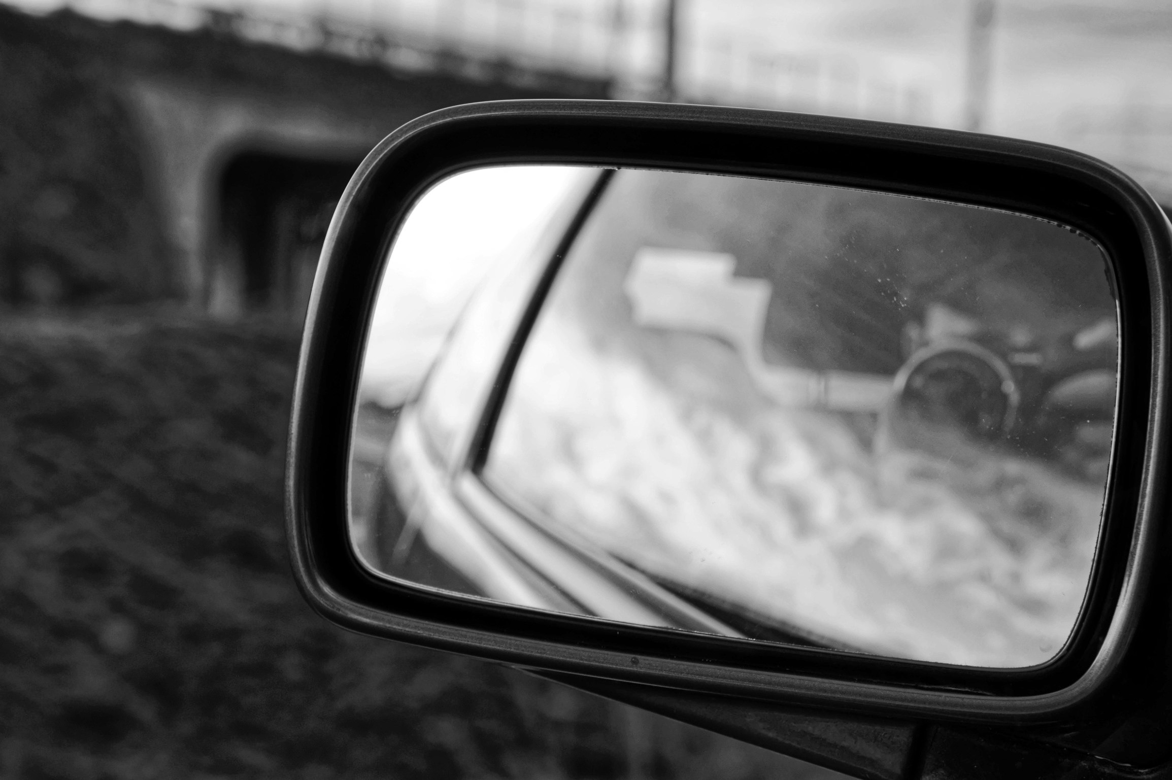 paesaggio stradale riflesso nello specchietto laterale dell’auto