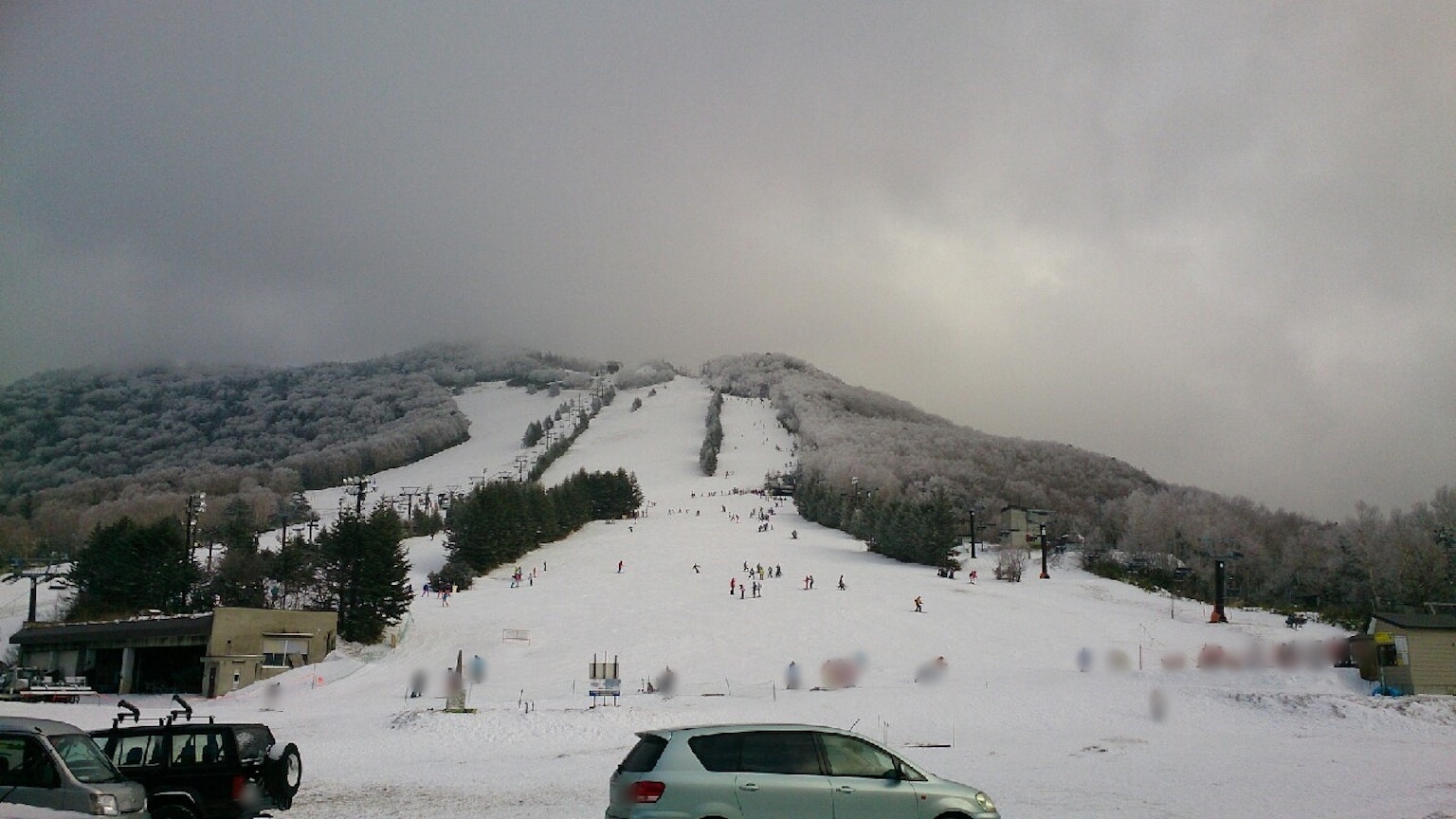 Schneebedeckter Berg mit Skipisten und bewölktem Himmel