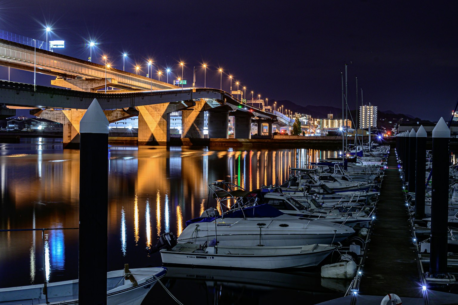 Bella riflessione di barche e ponte nel porto notturno