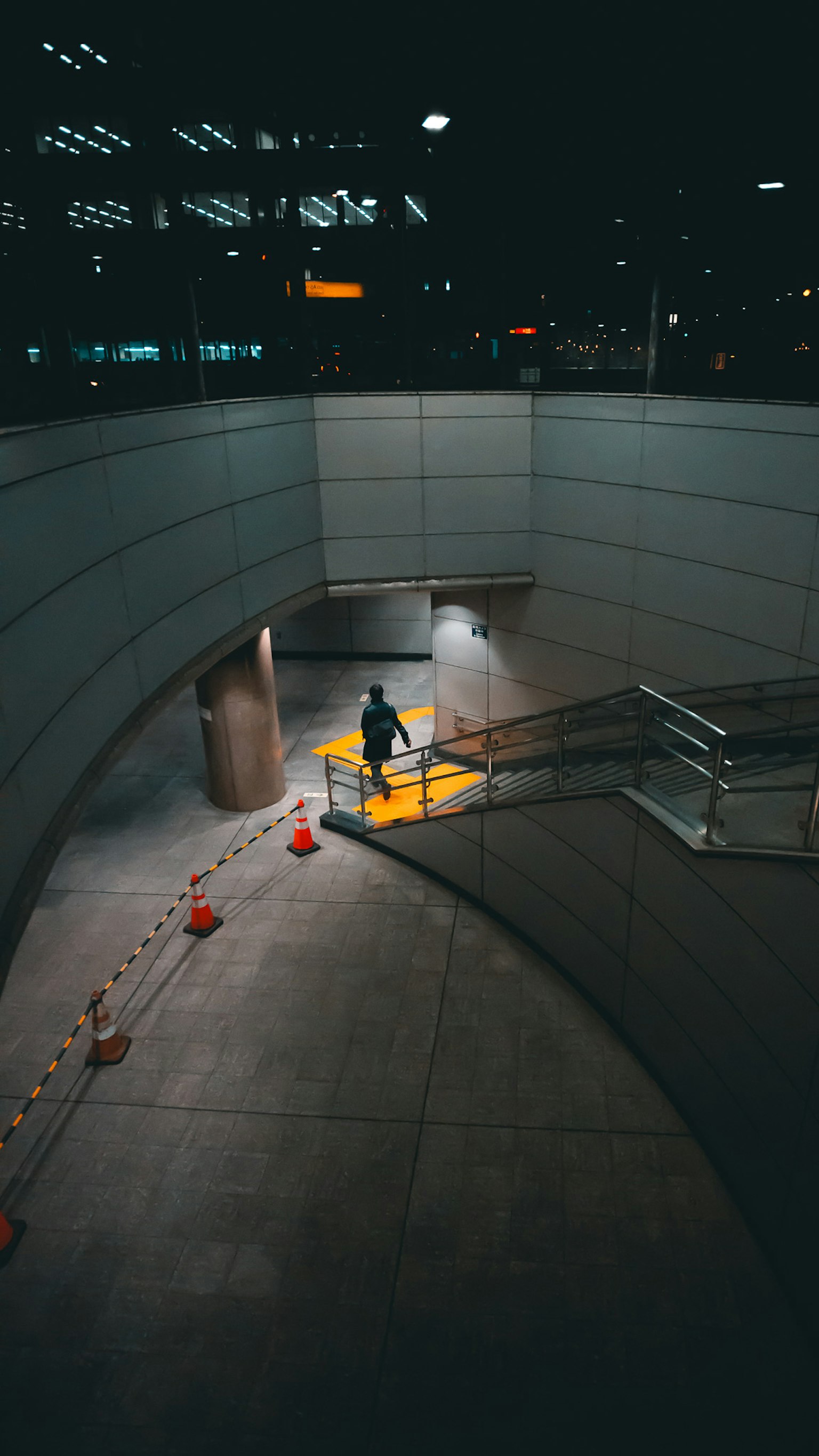 一个人在昏暗的地下通道中走动，周围有明亮的灯光