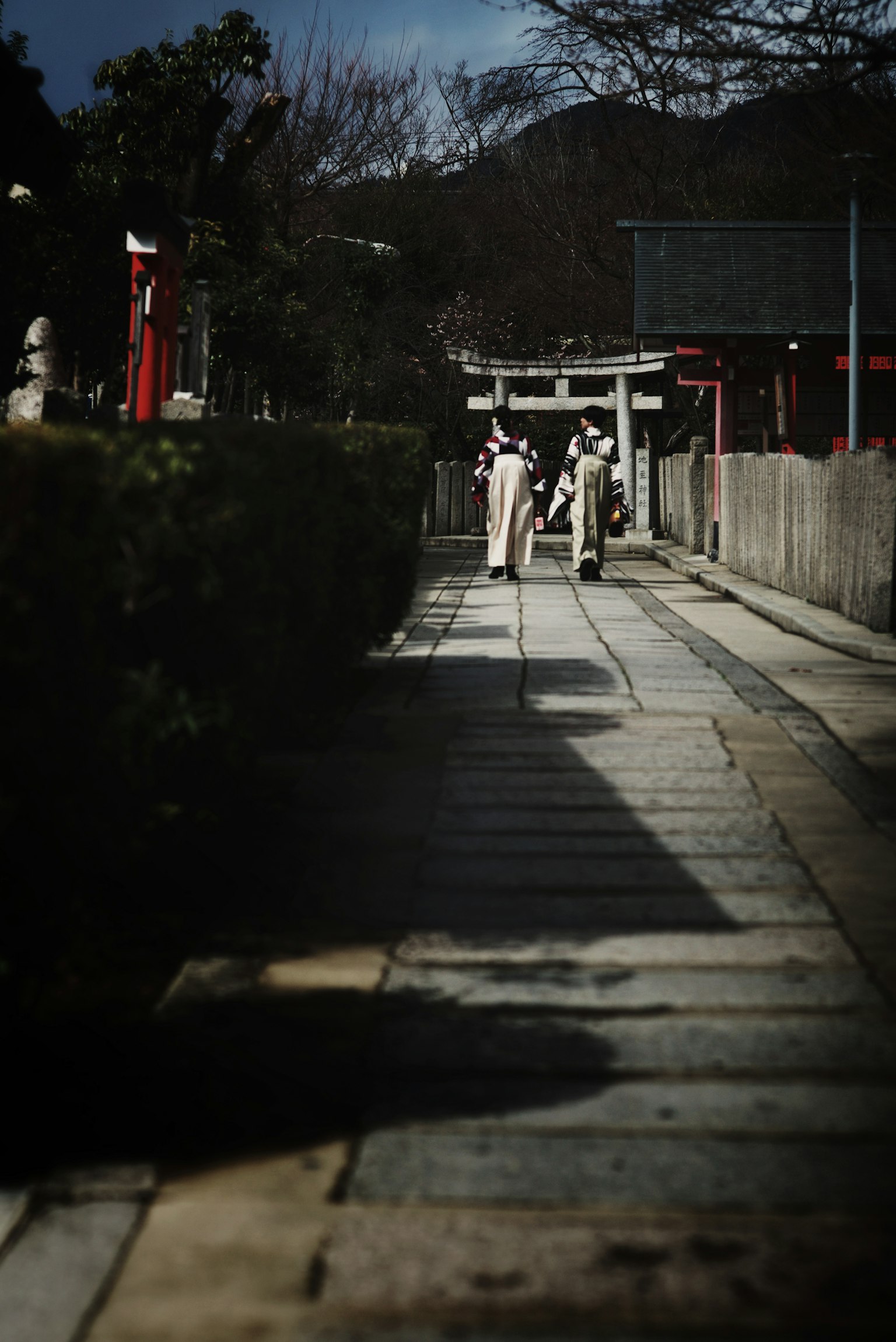 Femmes en kimonos marchant sur un chemin tranquille avec des ombres intéressantes