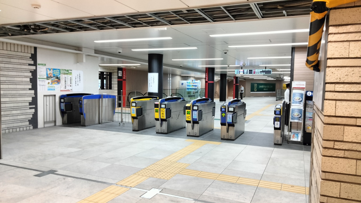 Interior of a train station showing ticket gates with bright lighting and spacious layout