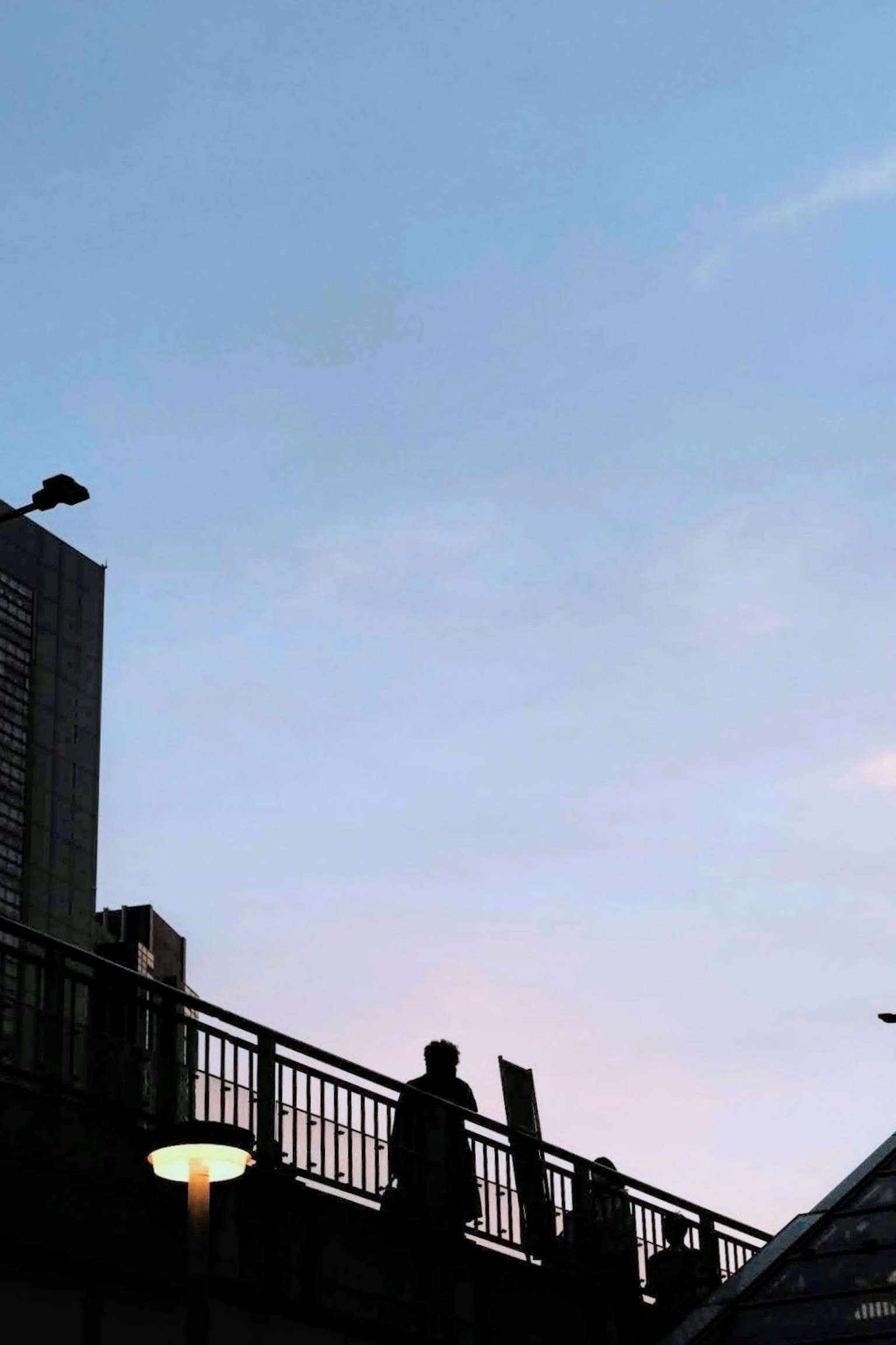 Silhouettes de personnes contre un ciel de coucher de soleil et contours de bâtiments