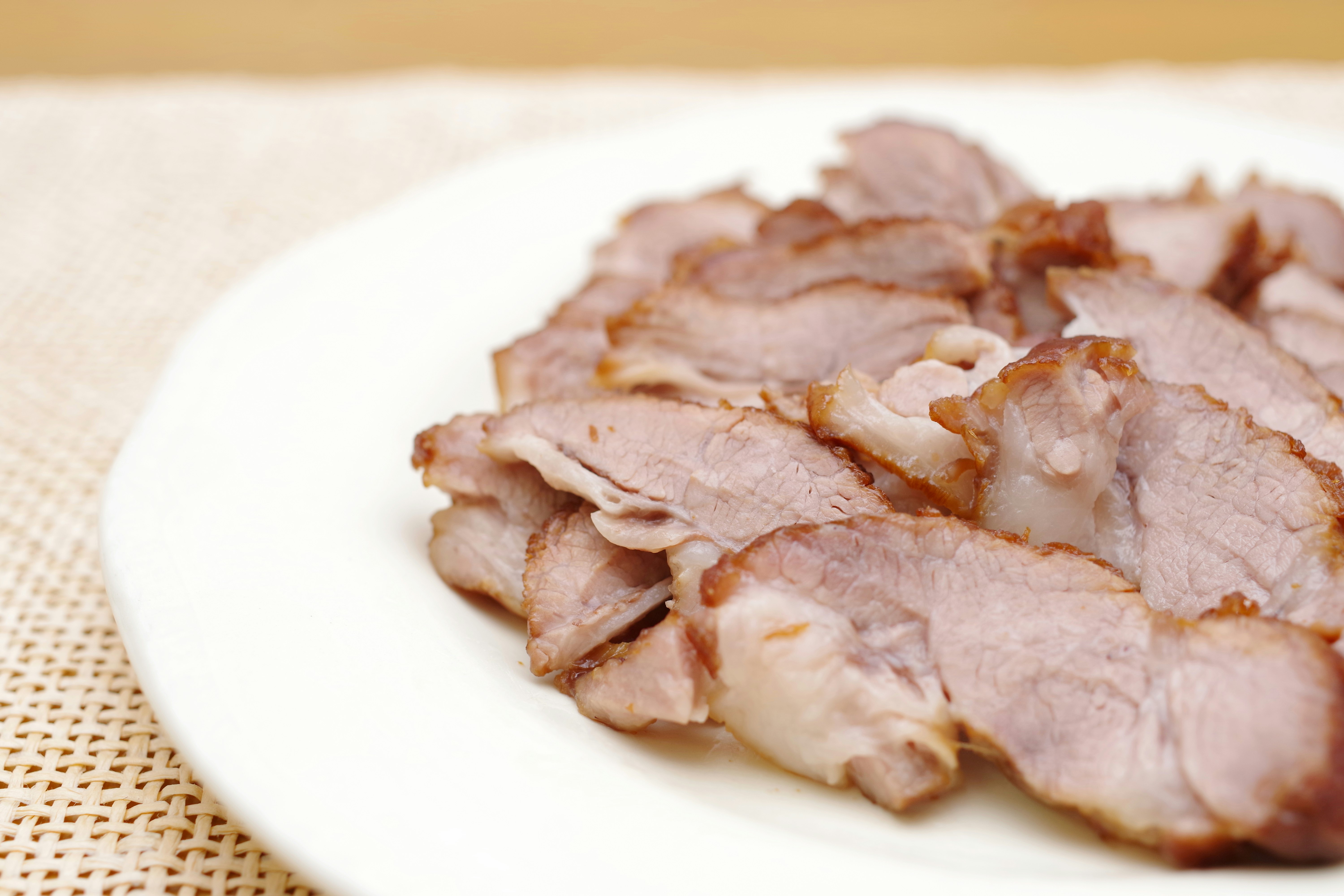 豚肉の薄切りが白い皿に盛られた料理
