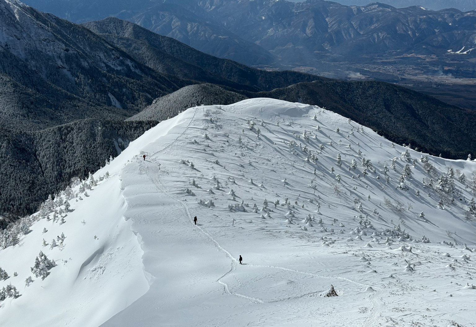 Crête montagneuse recouverte de neige avec des sommets lointains