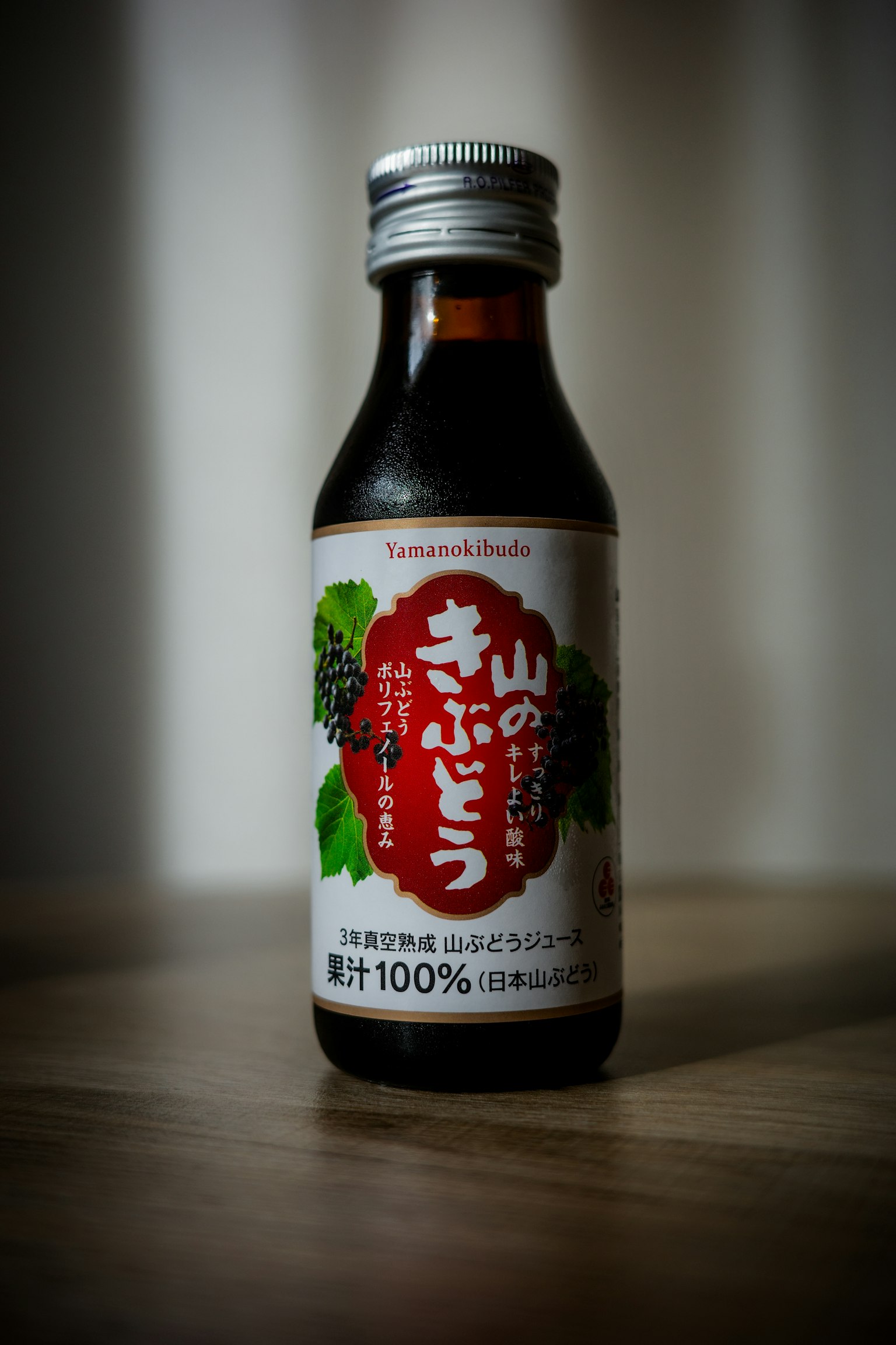 A black bottle containing mountain grape juice with Japanese label details