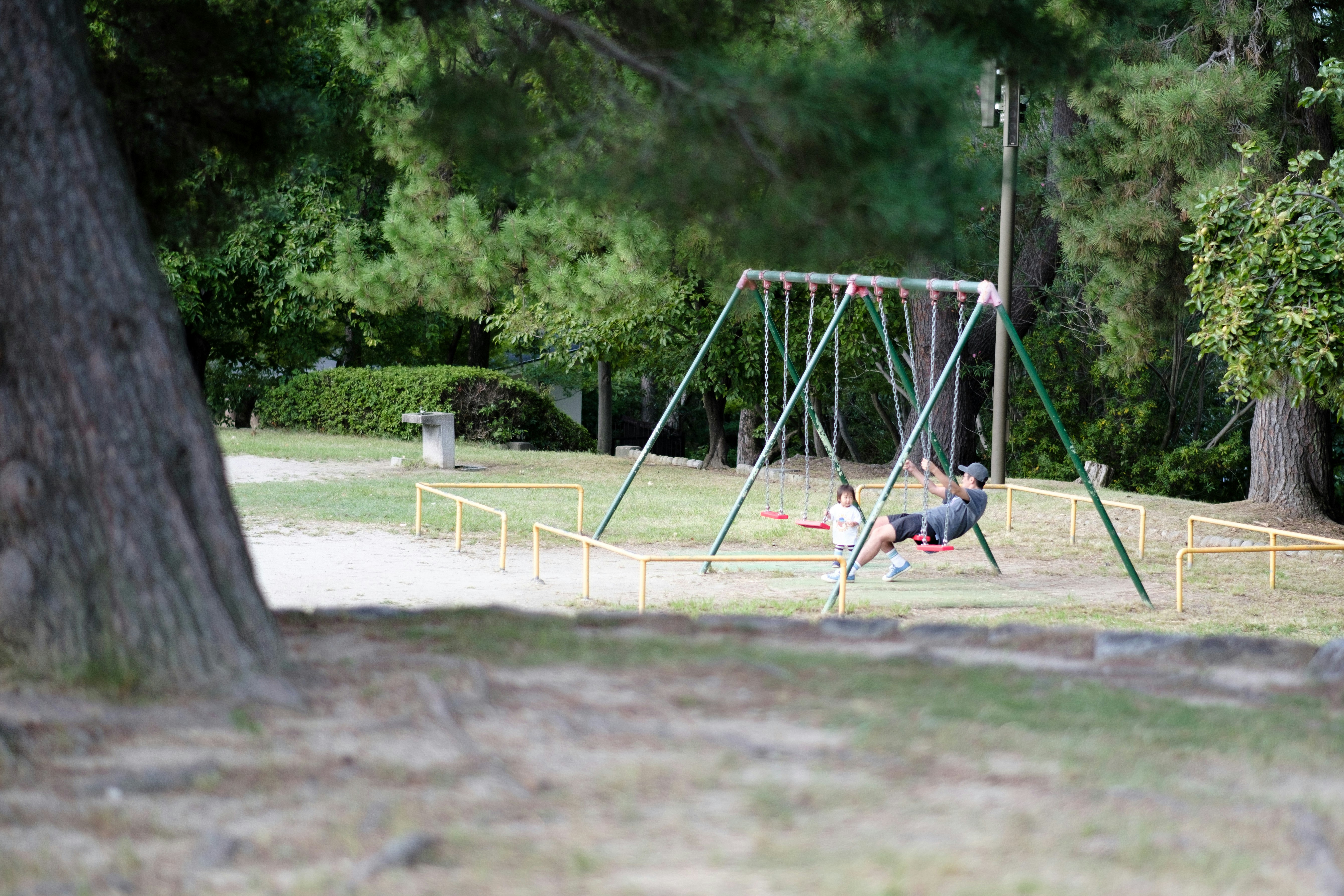 公園のブランコで遊ぶ子どもたち