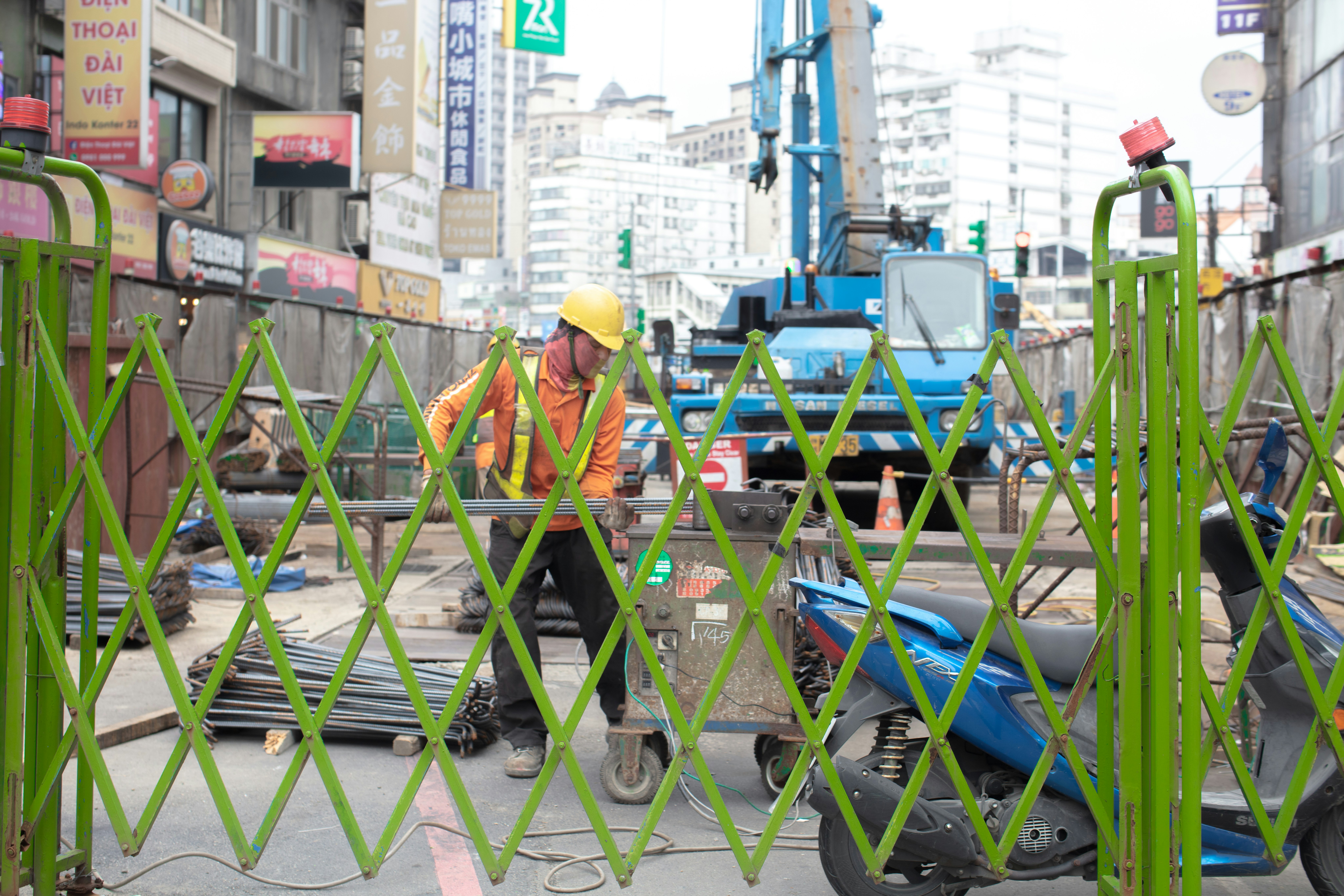 工事現場の作業員がバリケードの前で作業する都市の街角