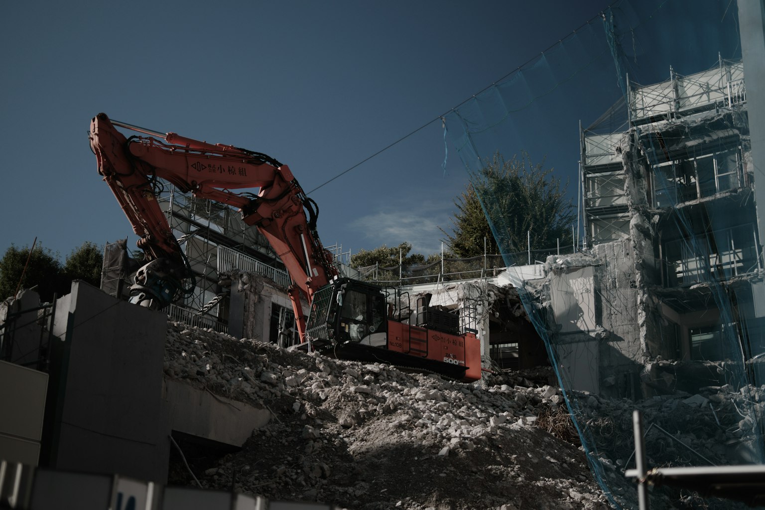 Excavator demolishing a building at a construction site
