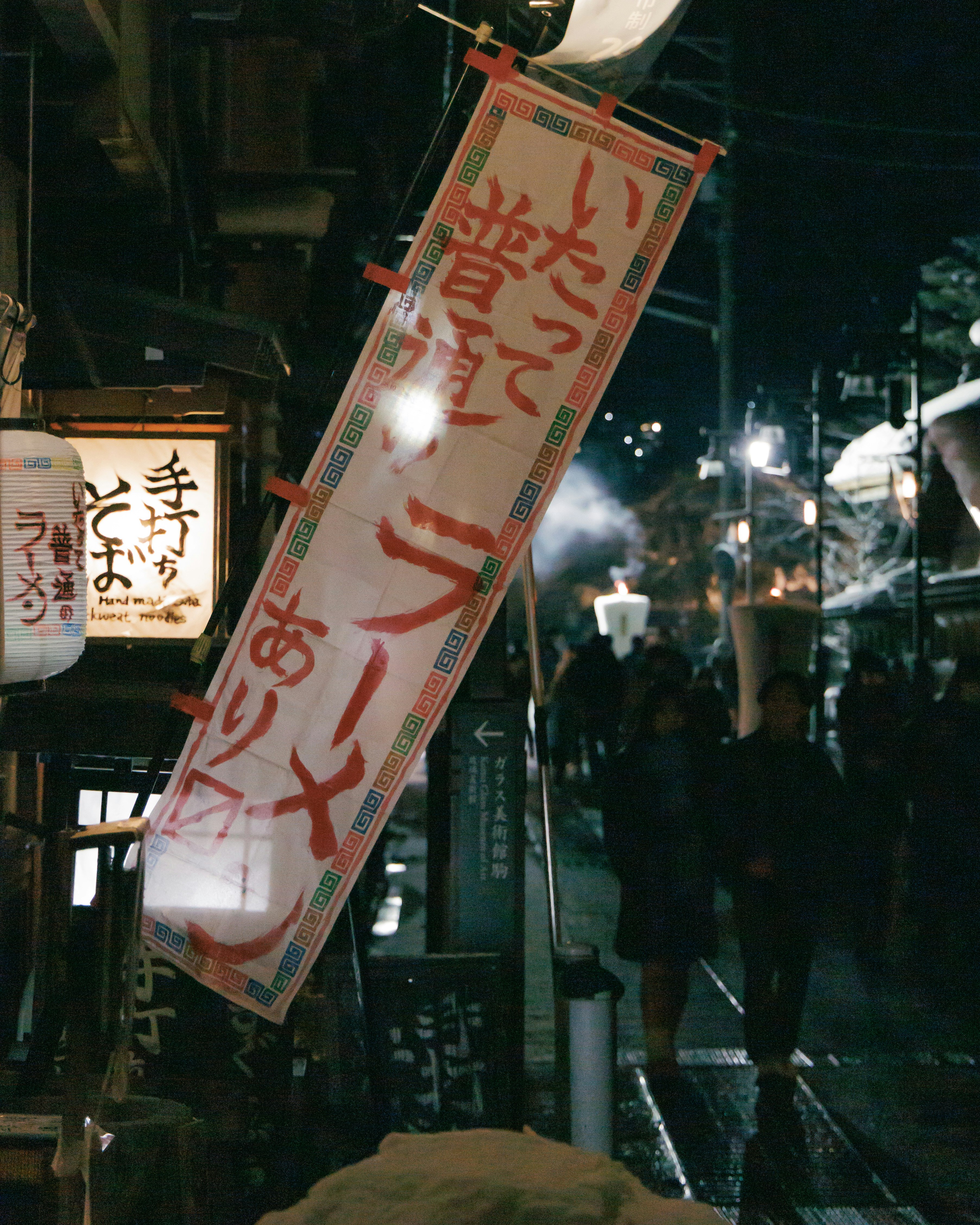 夜晚巷弄裡懸掛的招牌與燈籠點亮的餐飲街氛圍