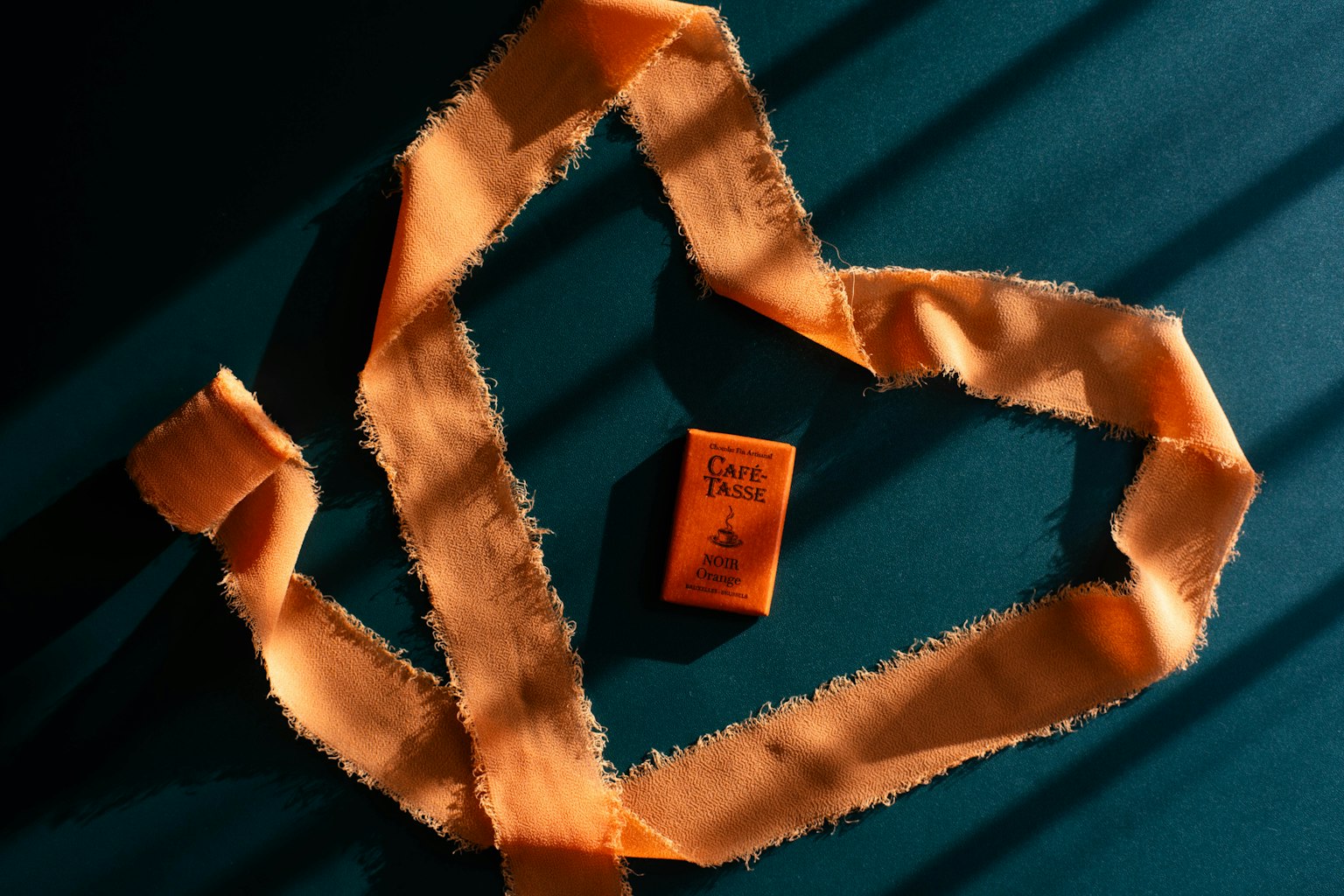 An orange fabric arranged in a heart shape with a small orange object placed in the center