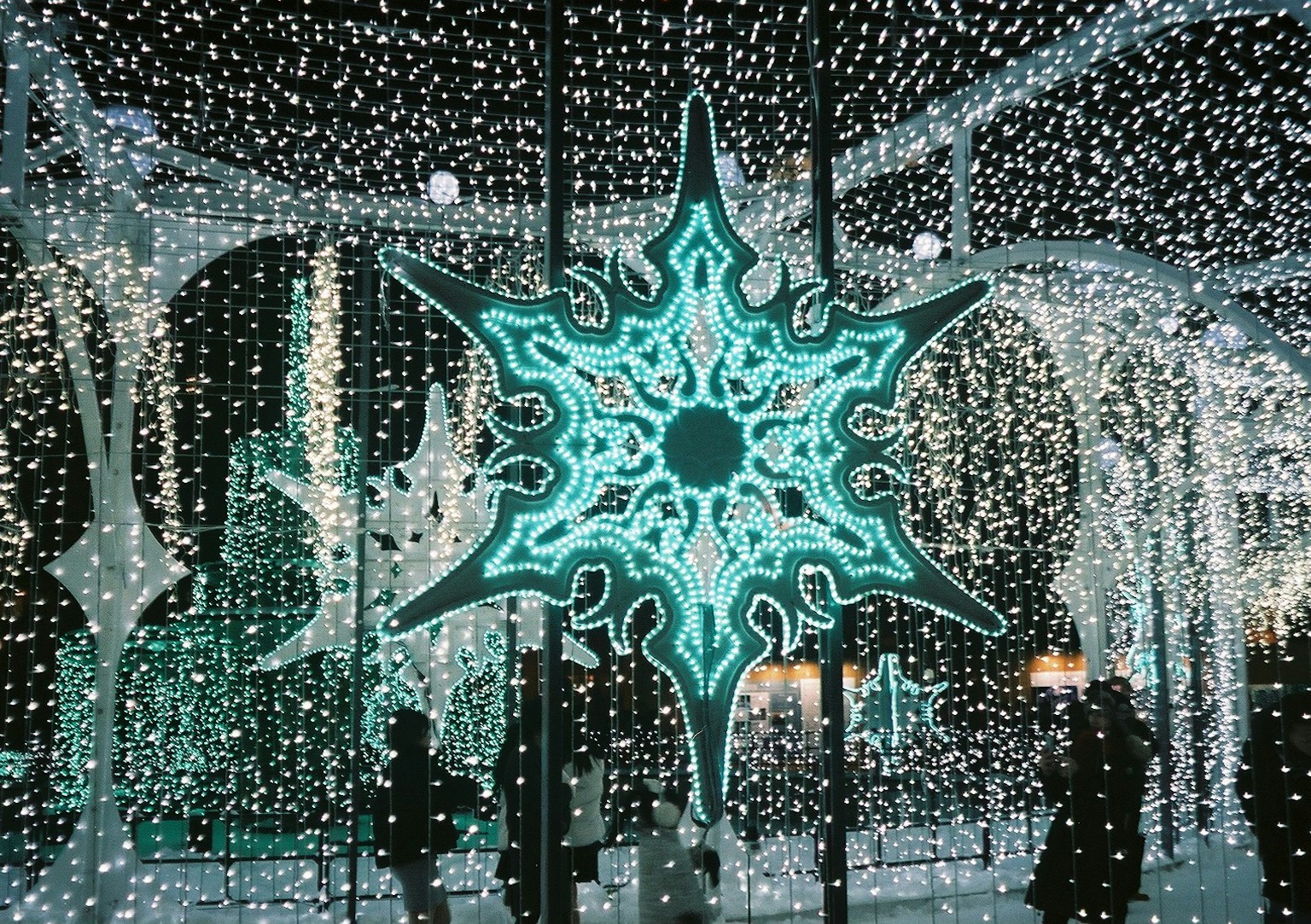 Scena invernale con decorazione a forma di fiocco di neve blu circondata da luci