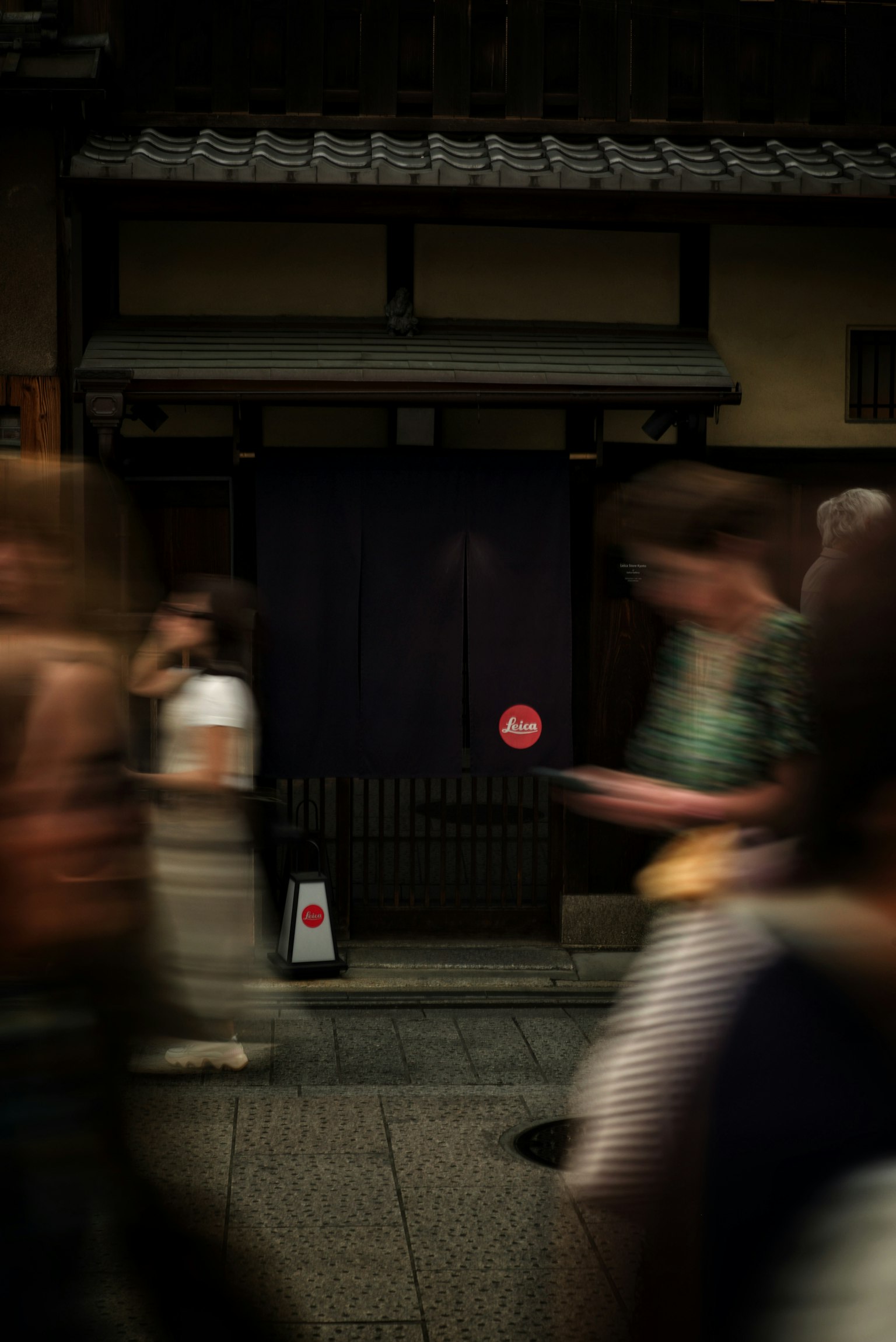 Mọi người đi bộ trên đường phố Kyoto đi qua một ngôi nhà Nhật Bản cổ xưa