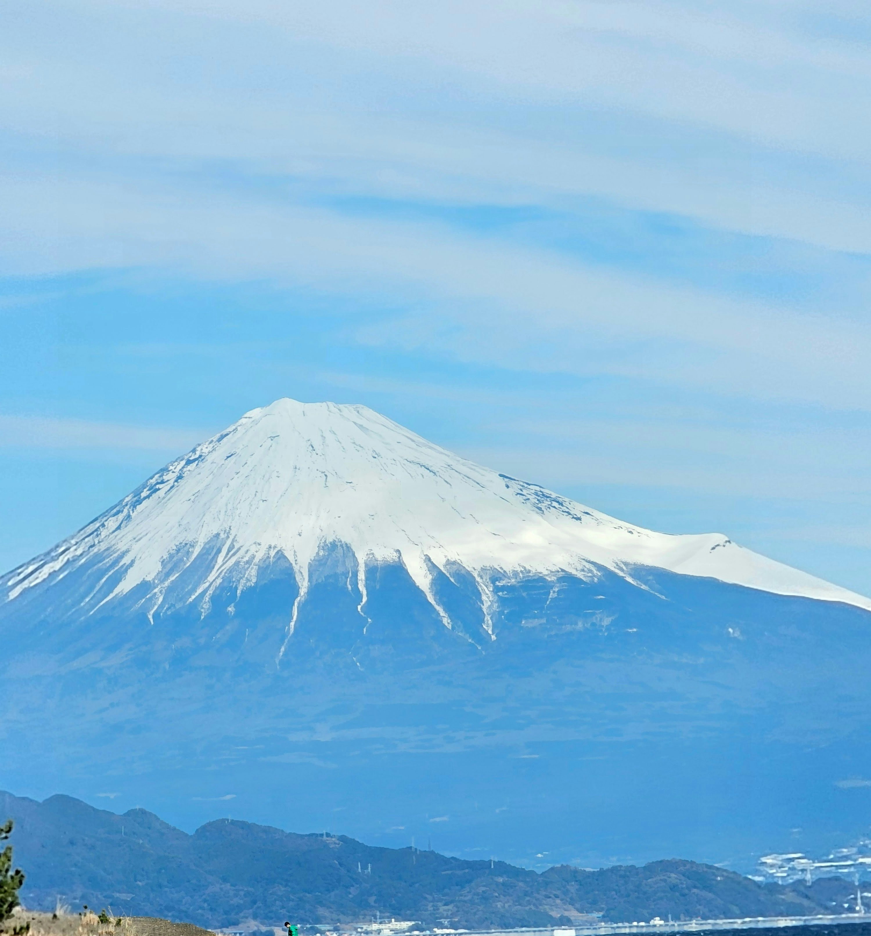 青空の下にそびえる雪をかぶった山のシルエット