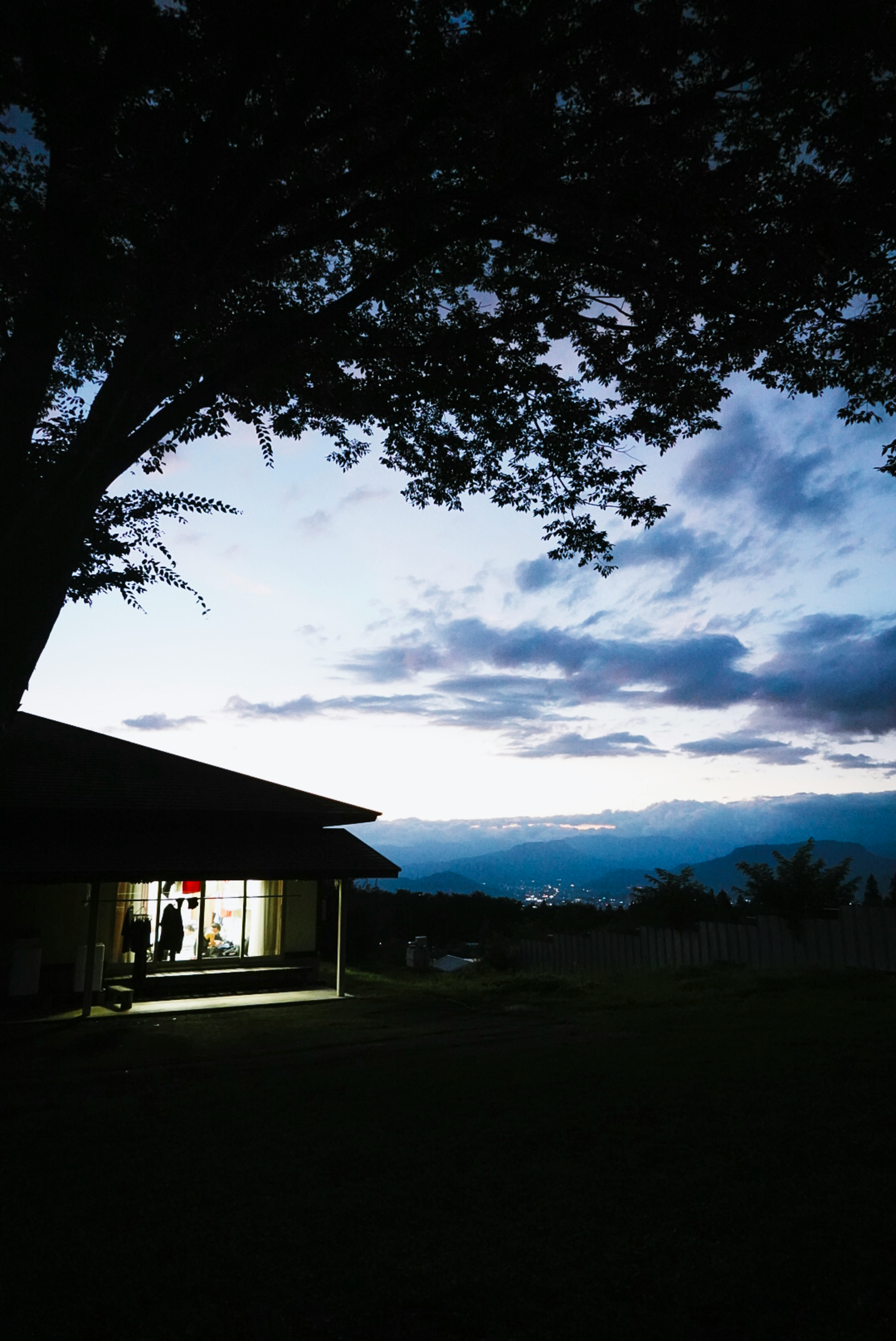 夕暮れの庭と山並みを見渡す家の軒先