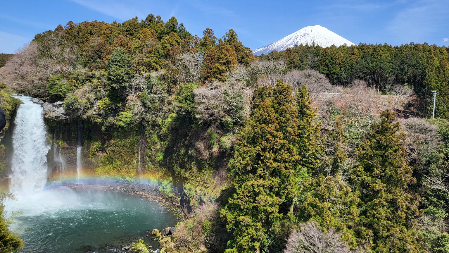 美麗的瀑布和山景 瀑布下可見彩虹 富士山在背景中