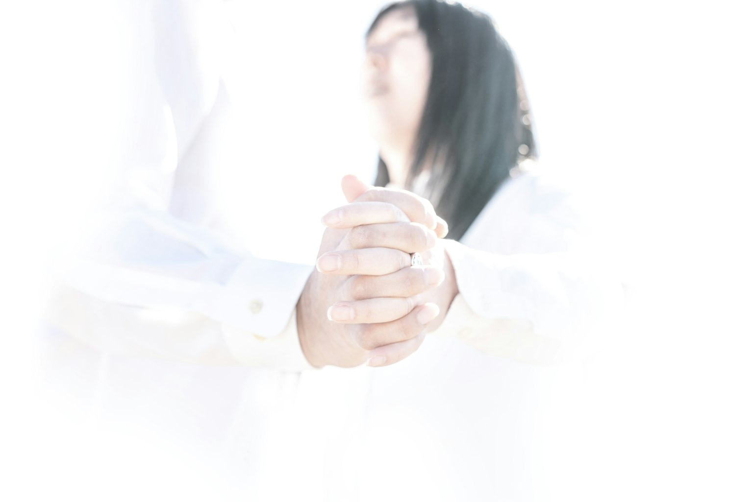 밝은 배경에서 손을 잡고 있는 두 사람