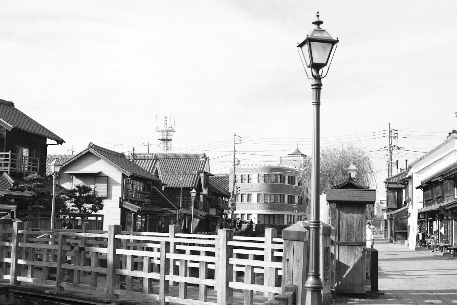 Paisaje en blanco y negro con edificios japoneses tradicionales y un puente con una farola