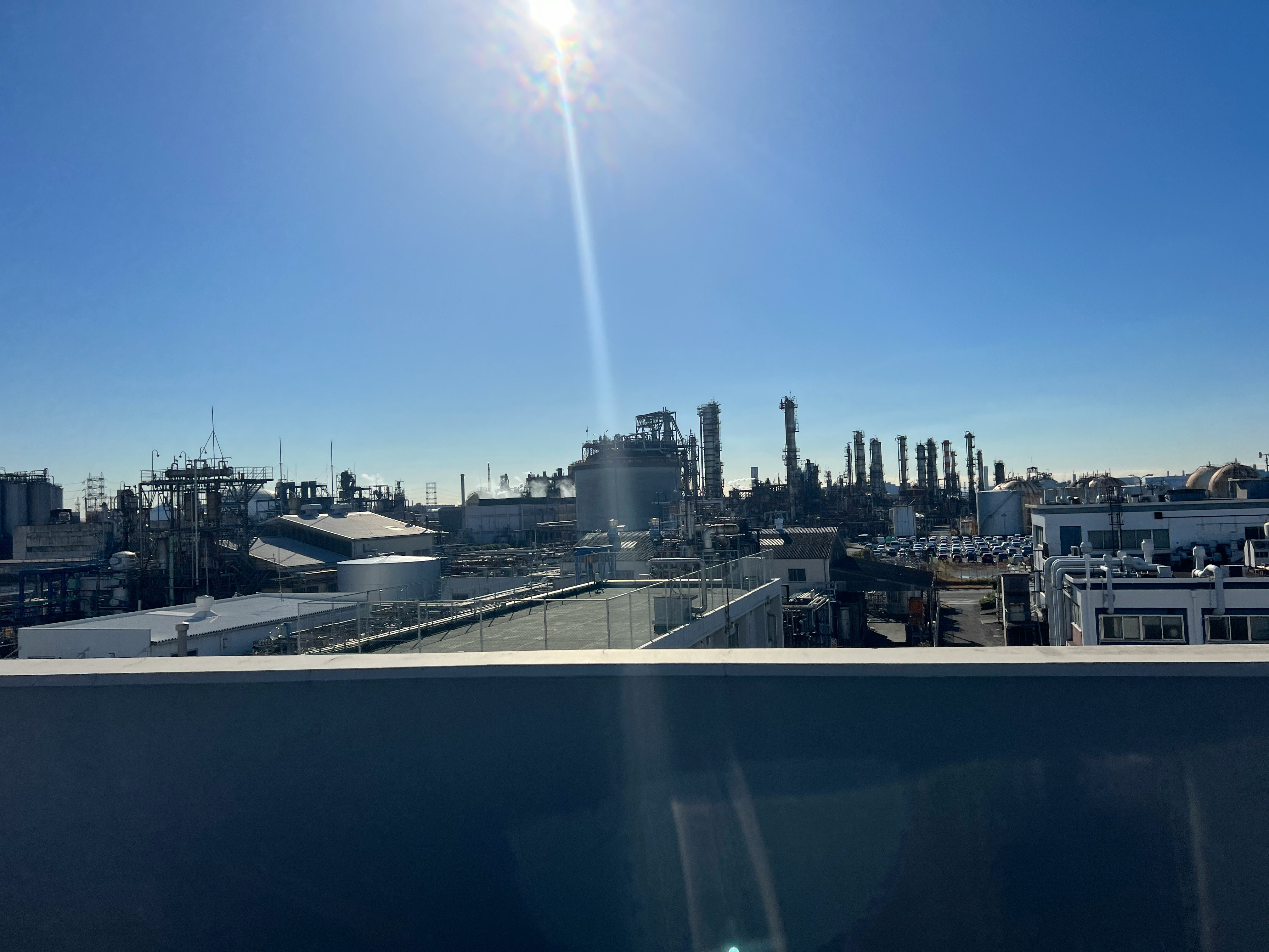 從屋頂俯瞰的工業區煙囪與生產設備景象