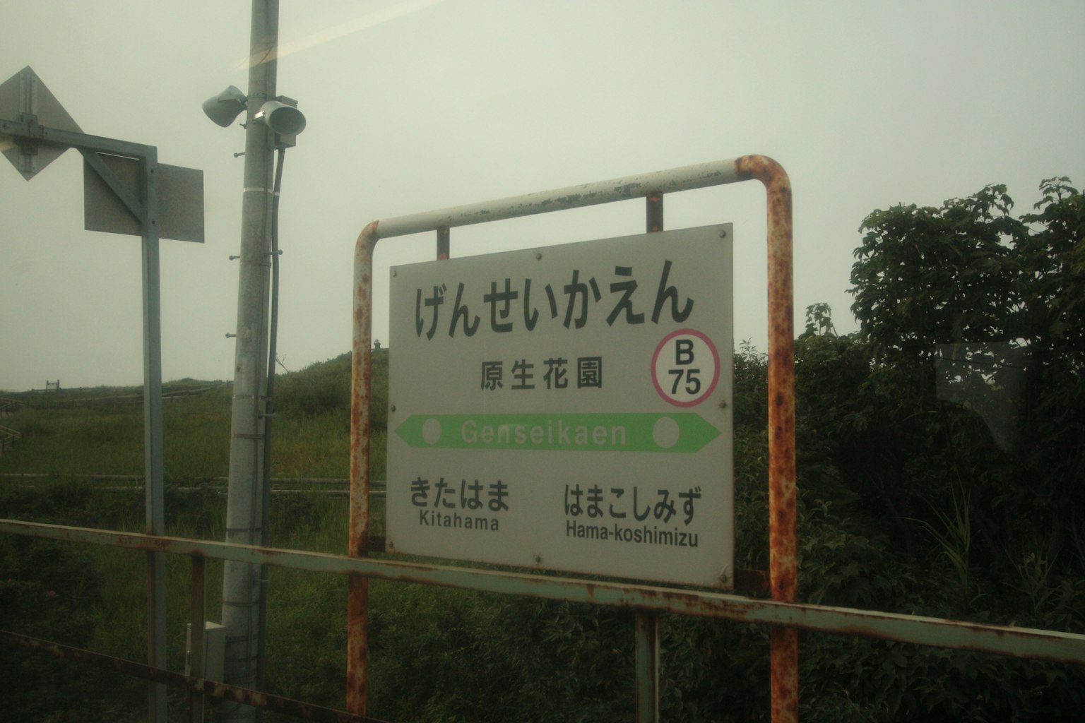 Cartel de la estación Genseikaan con fondo rural