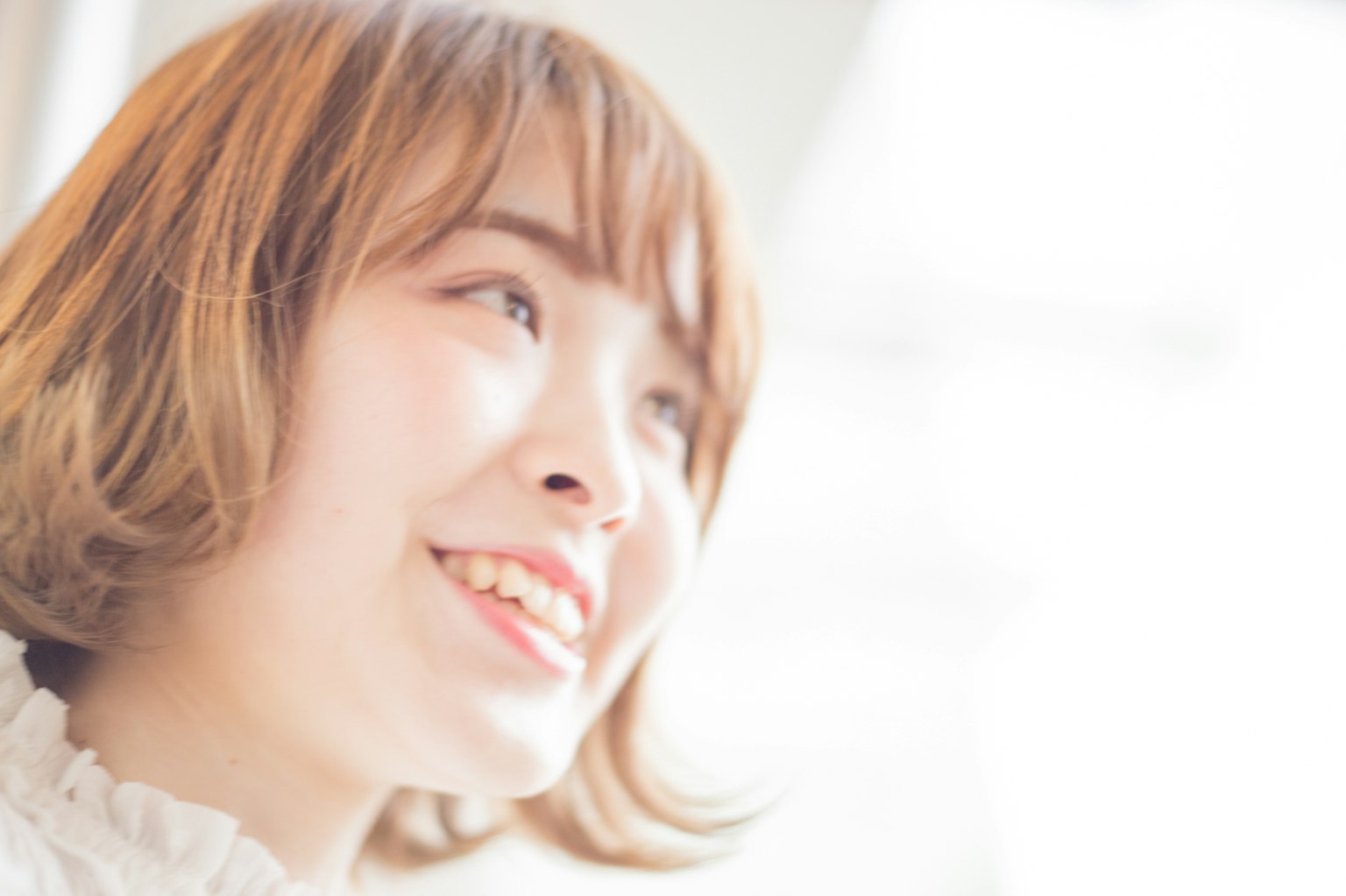 Portrait d'une femme souriante avec des cheveux doux et un fond lumineux
