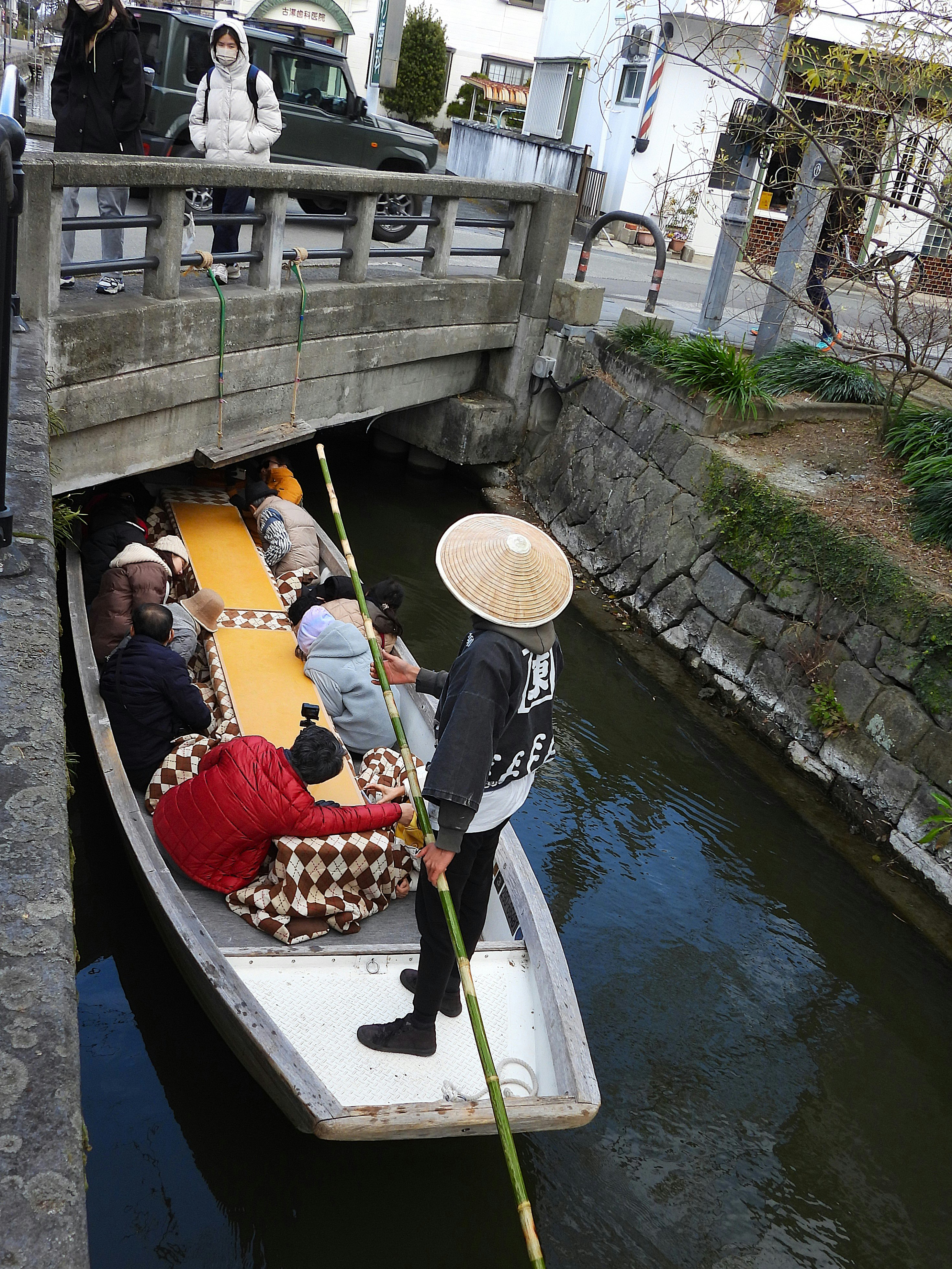 Barca kotatsu navegando por los canales de Yanagawa bajo un puente bajo