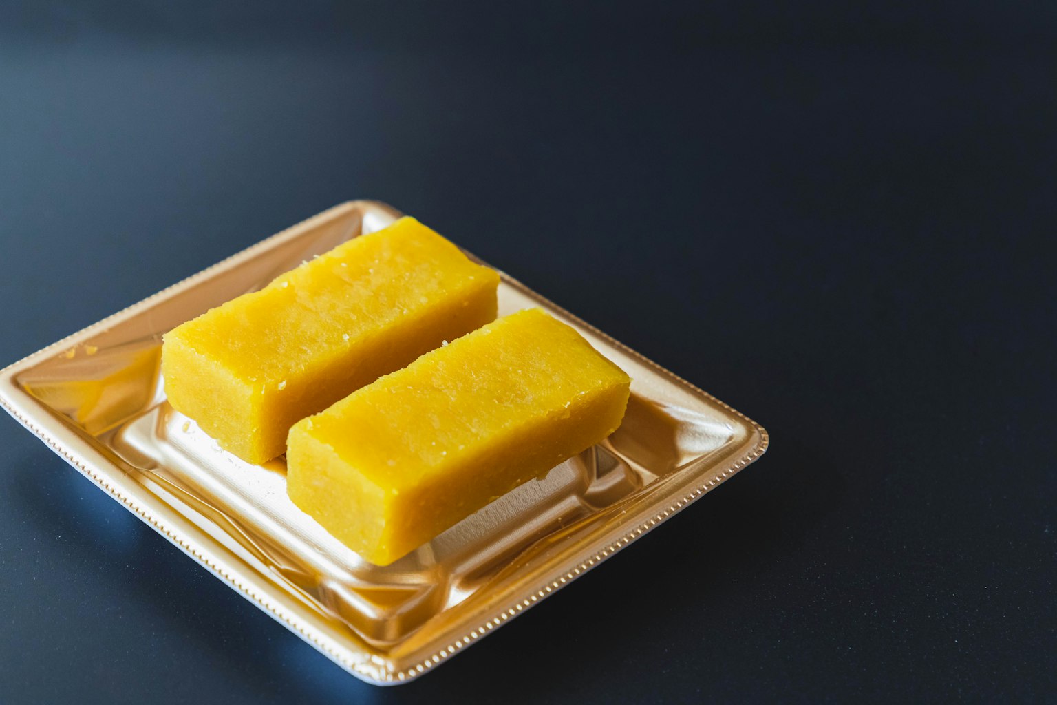 白色盤子上的兩個黃色甜點