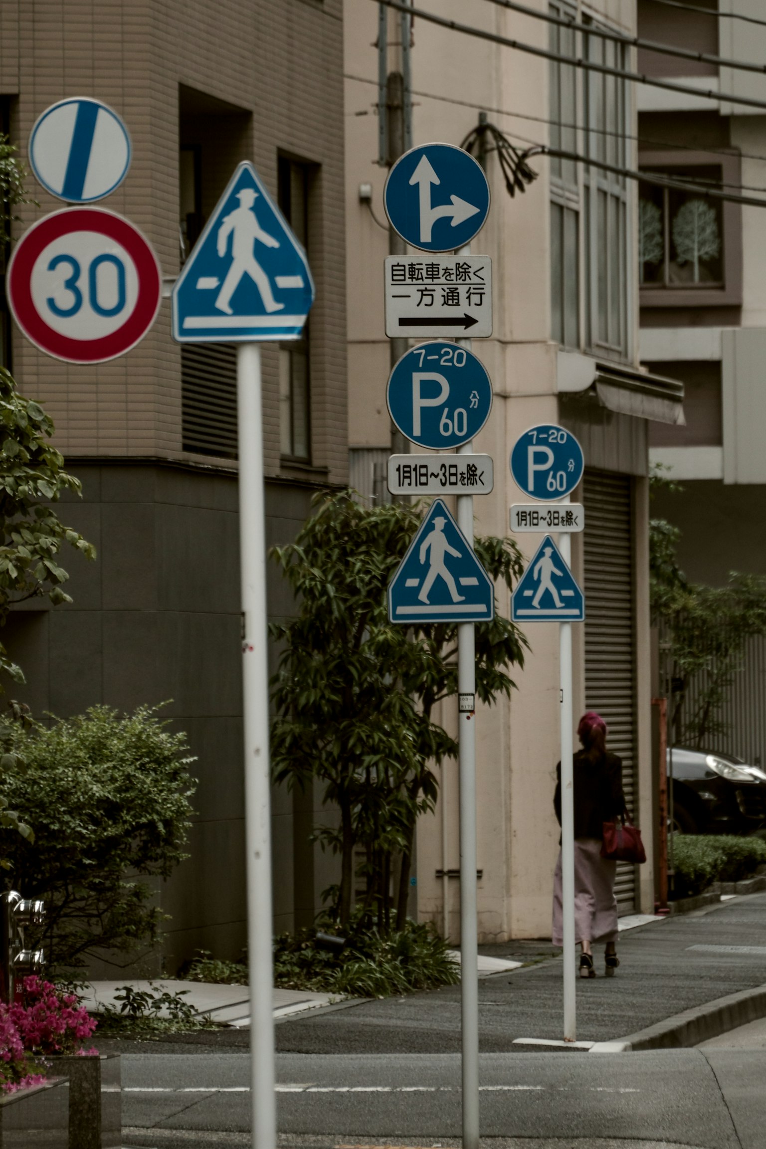 Angolo di strada con segnali pedonali e di parcheggio in un contesto urbano
