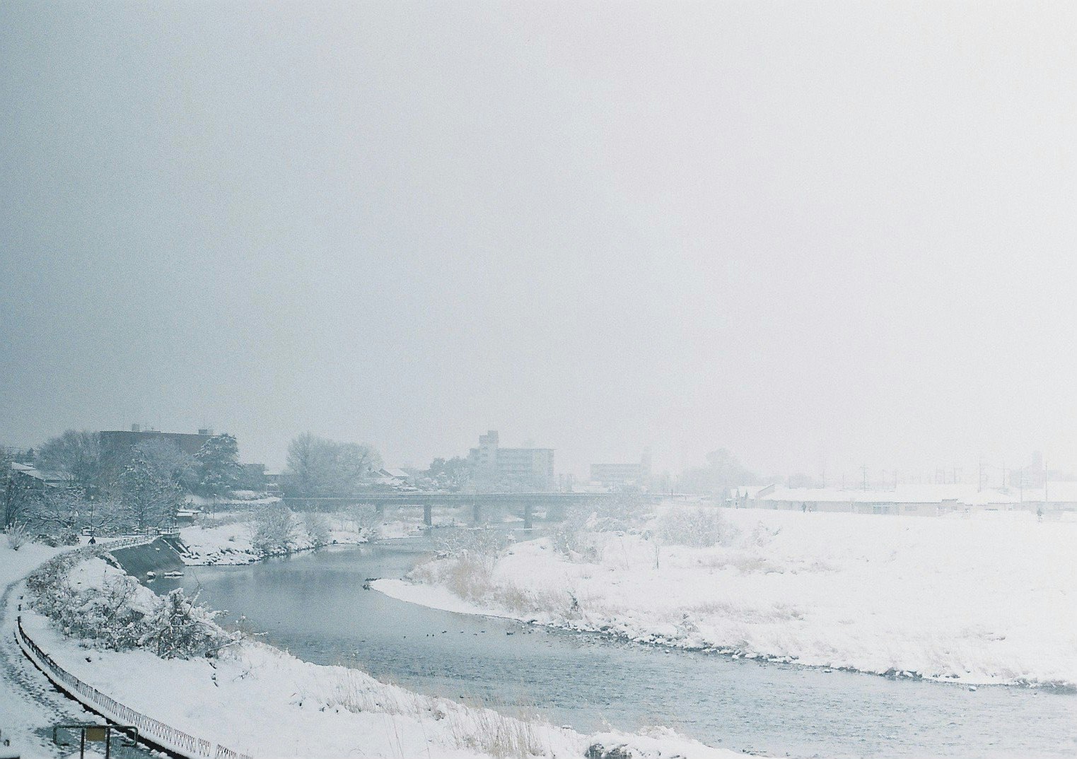 積雪覆蓋的河岸步道與岸邊景色