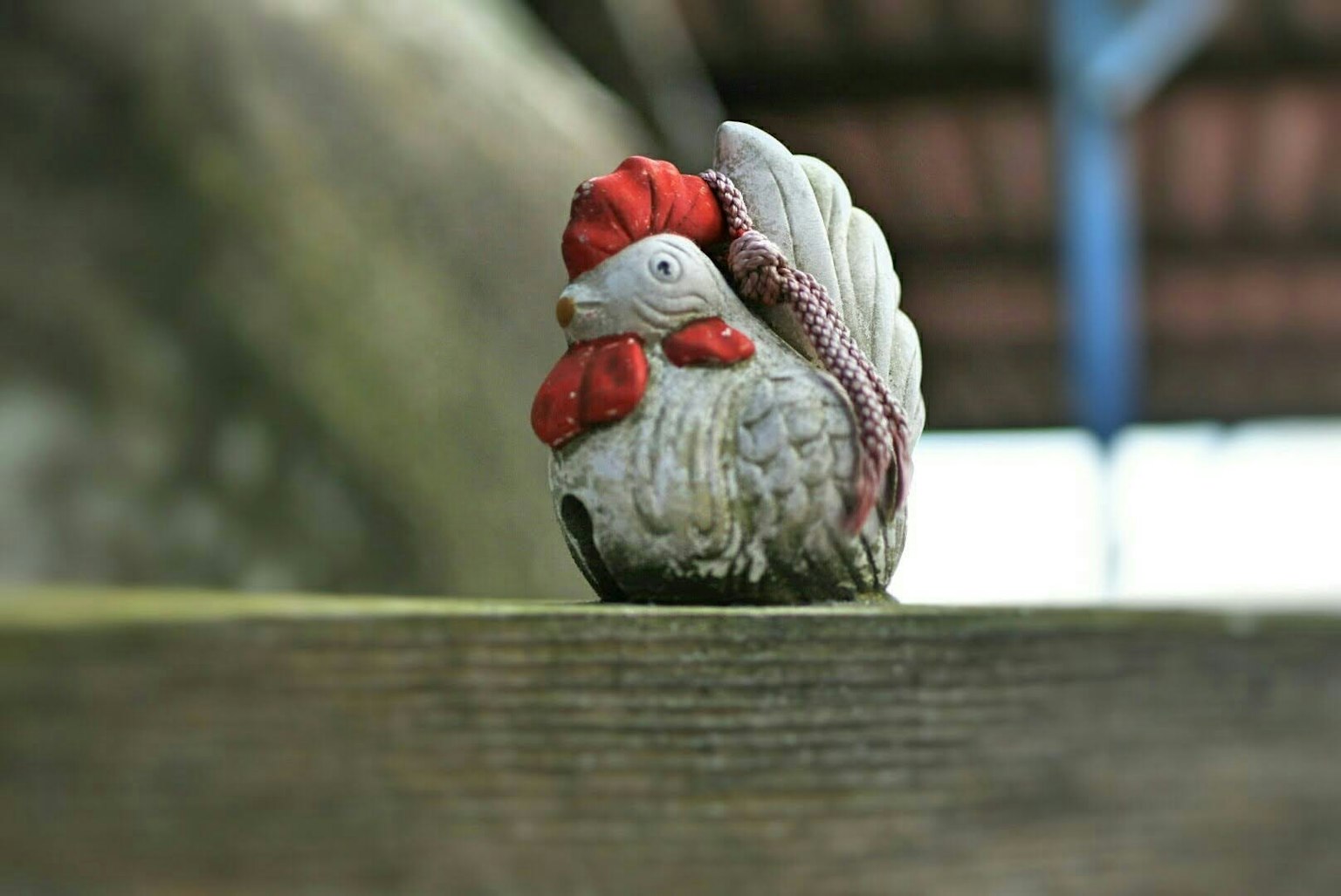 Una piccola statuetta di gallo su una superficie di legno