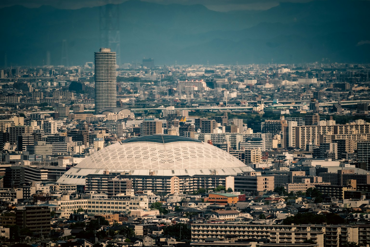Un grand stade en forme de dôme dans un paysage urbain avec des gratte-ciels