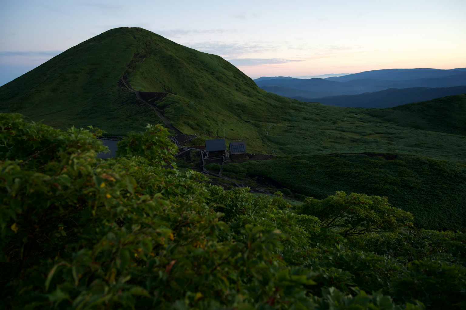一幅綠丘和遠山的黃昏景觀
