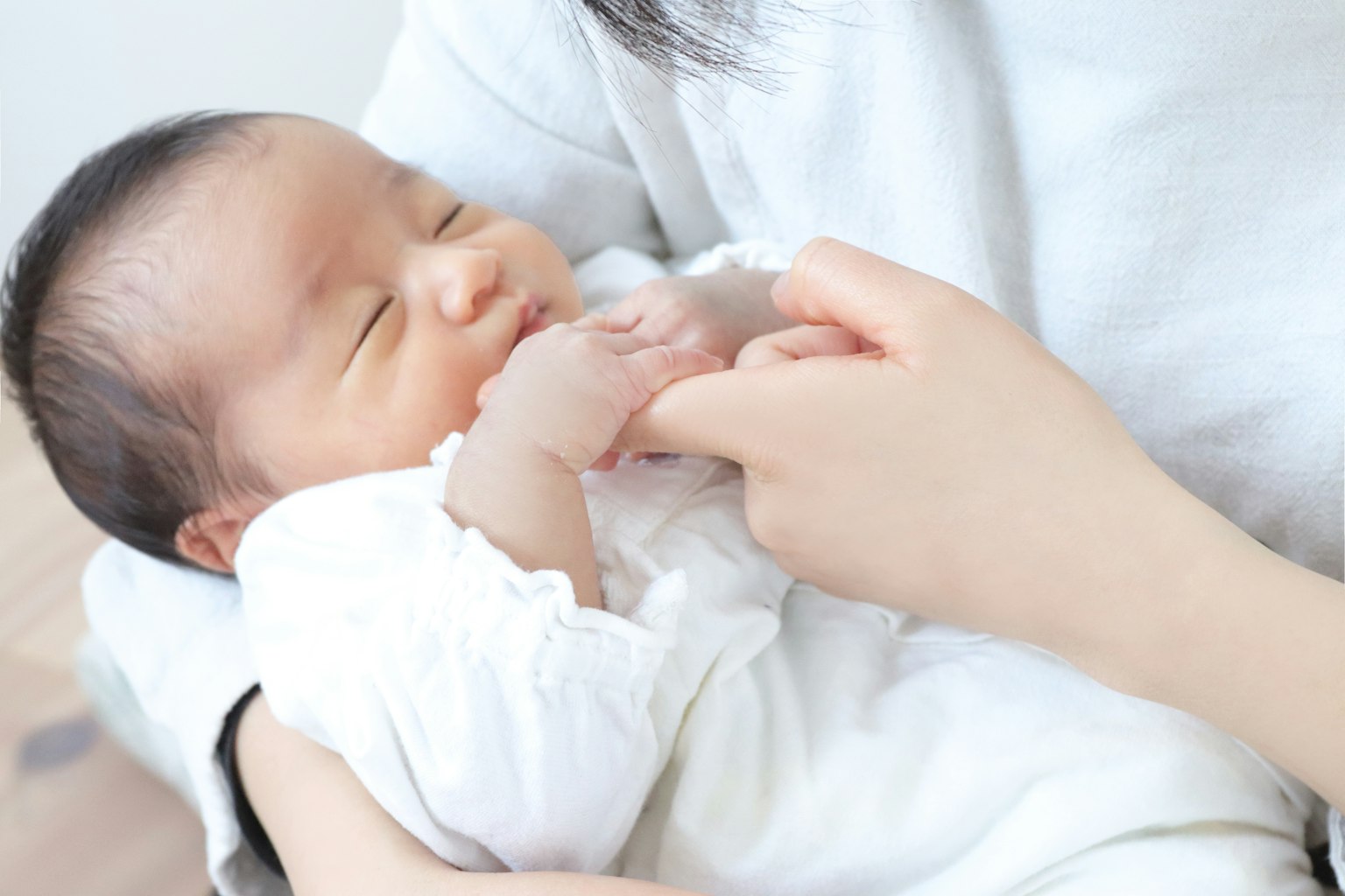A baby being gently held by a hand