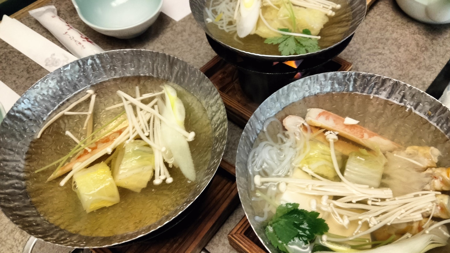 Three bowls of soup with vegetables and mushrooms