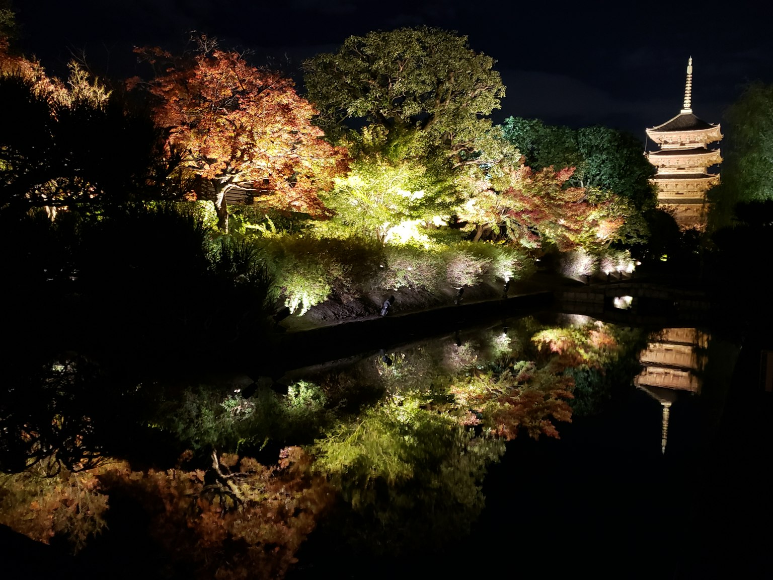 การสะท้อนที่สวยงามของใบไม้ฤดูใบไม้ร่วงและเจดีย์ในสวนตอนกลางคืน