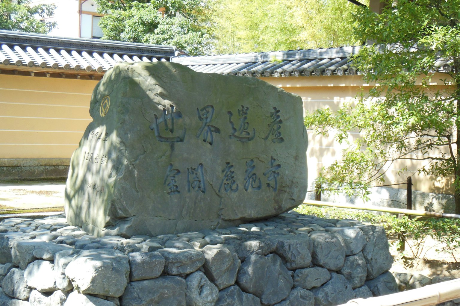 Monumento de piedra con inscripciones rodeado de vegetación