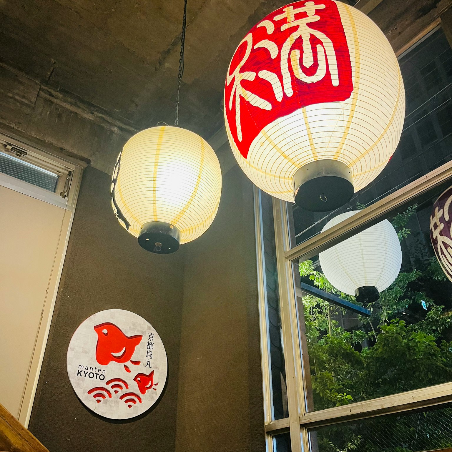 Lampion Jepang tradisional berwarna merah dan putih tergantung di sudut restoran yang nyaman