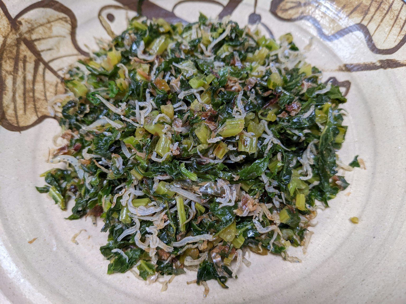 Une assiette de légumes verts mélangés et de petits poissons