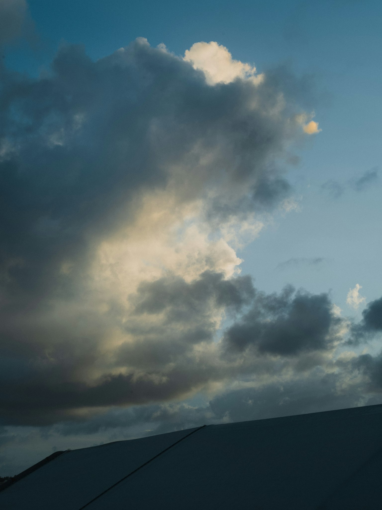 Langit dengan awan dan siluet atap