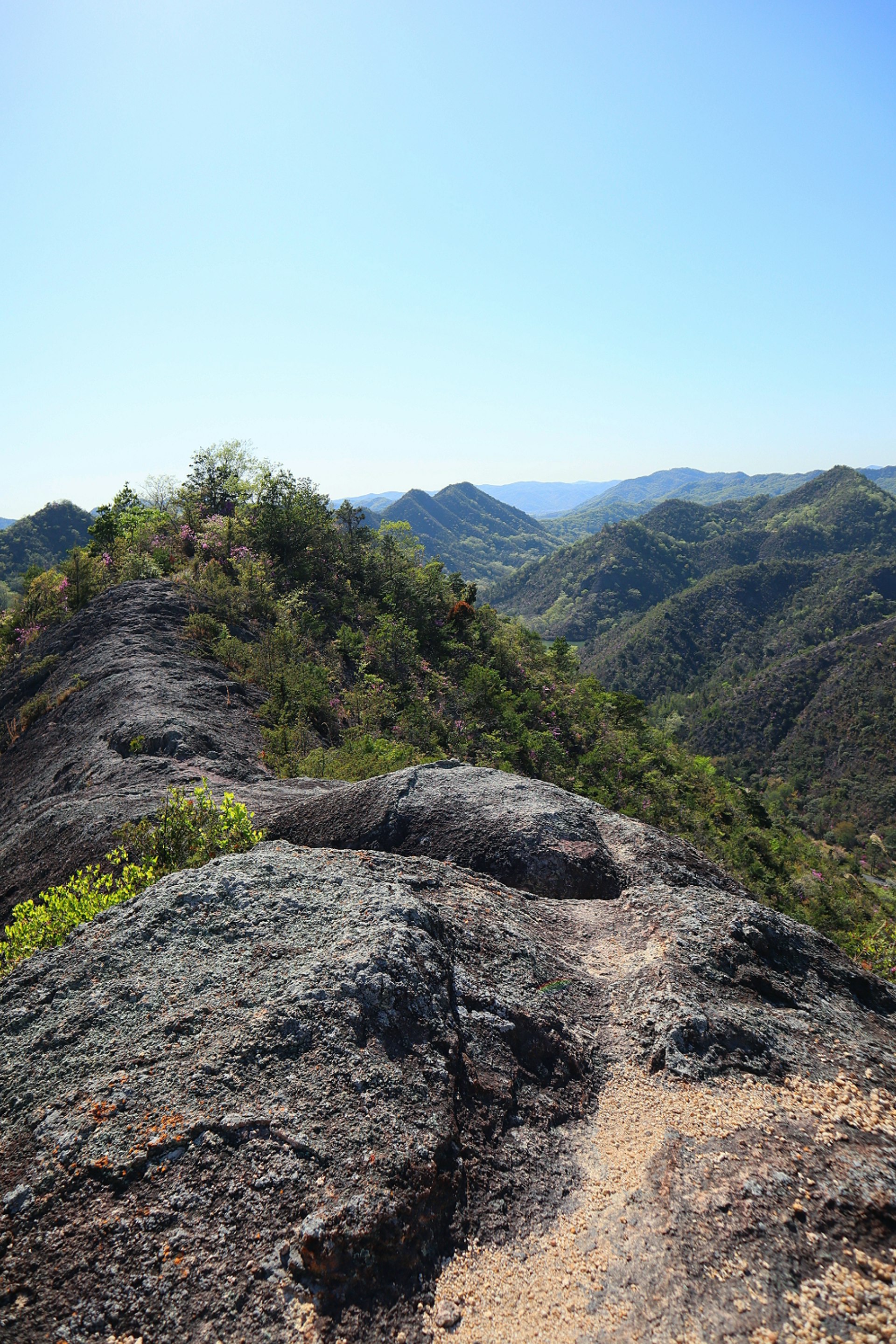 岩稜帯の岩場と山並みを見下ろす登山風景