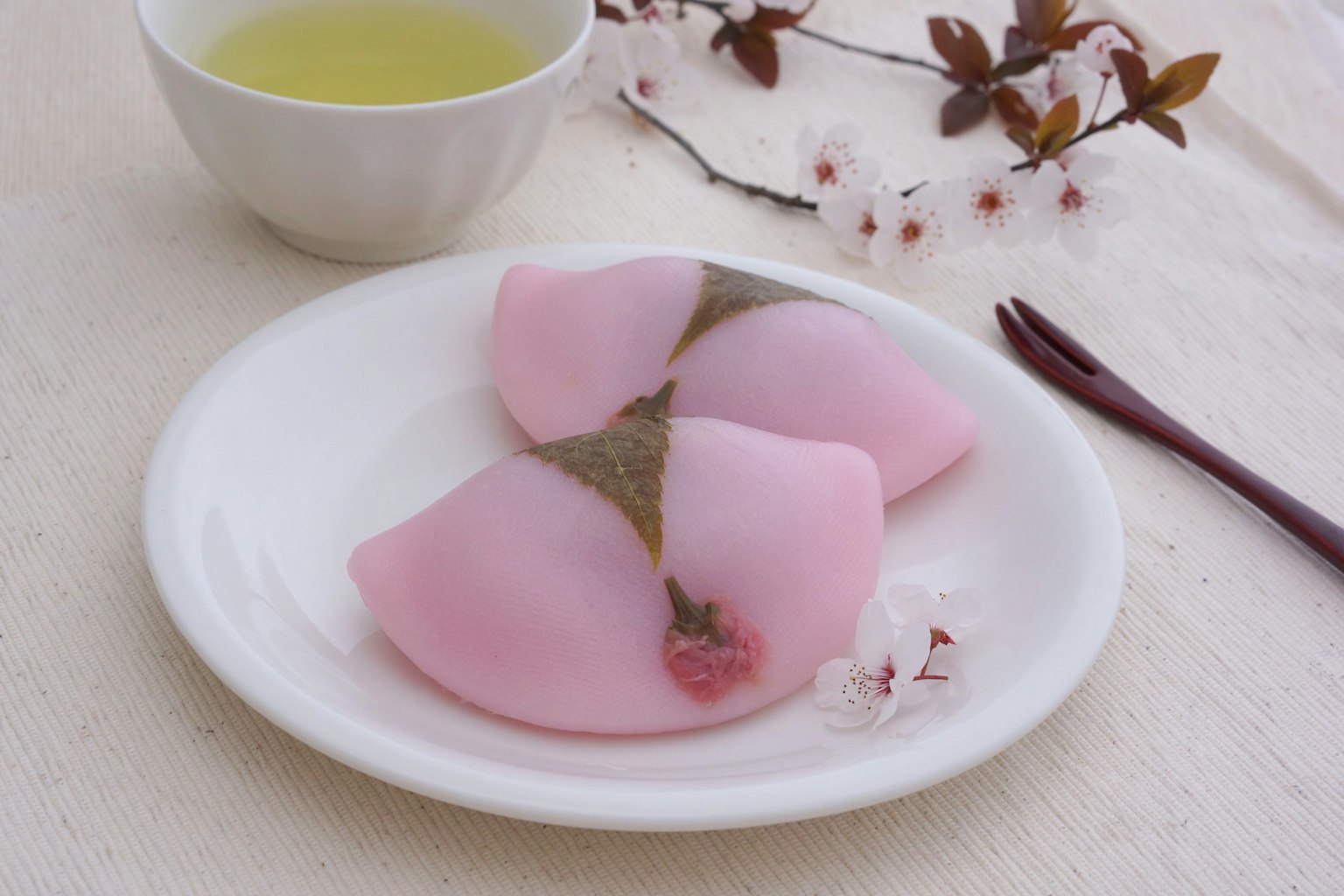 Hermosa disposición de la mesa con wagashi en forma de sakura y té verde