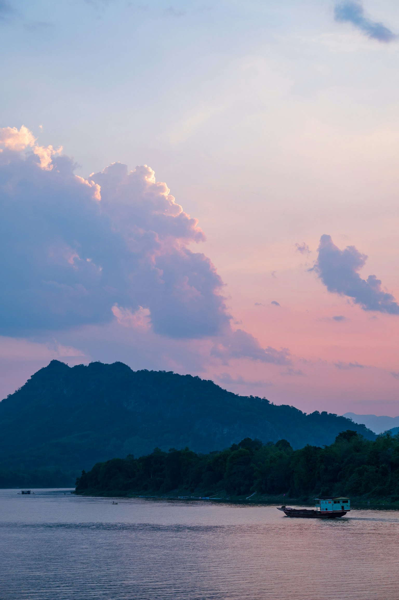 Paysage serein de la rivière avec un ciel au coucher du soleil et une silhouette de montagne