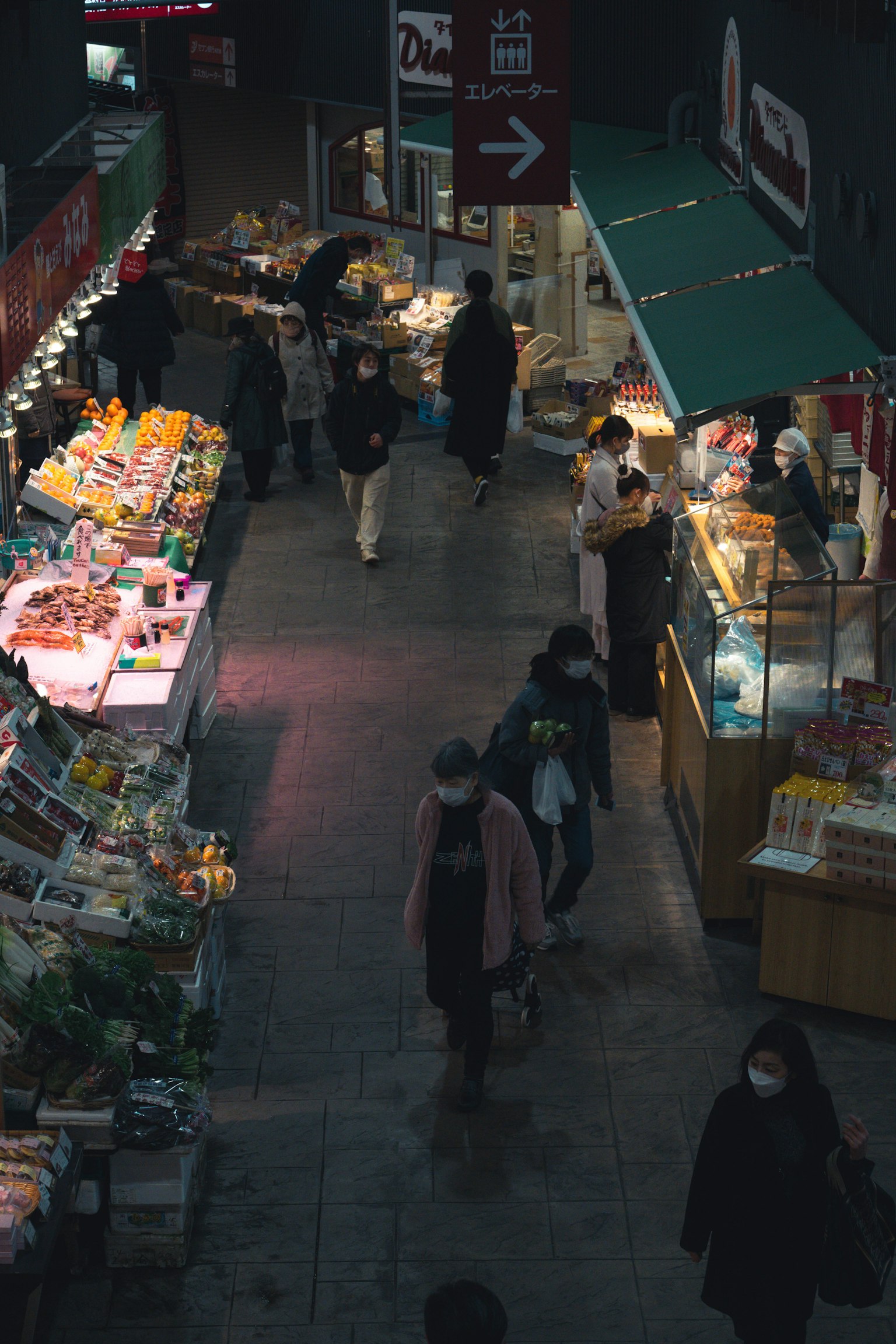 人们在市场上购物，周围是色彩斑斓的食品展示