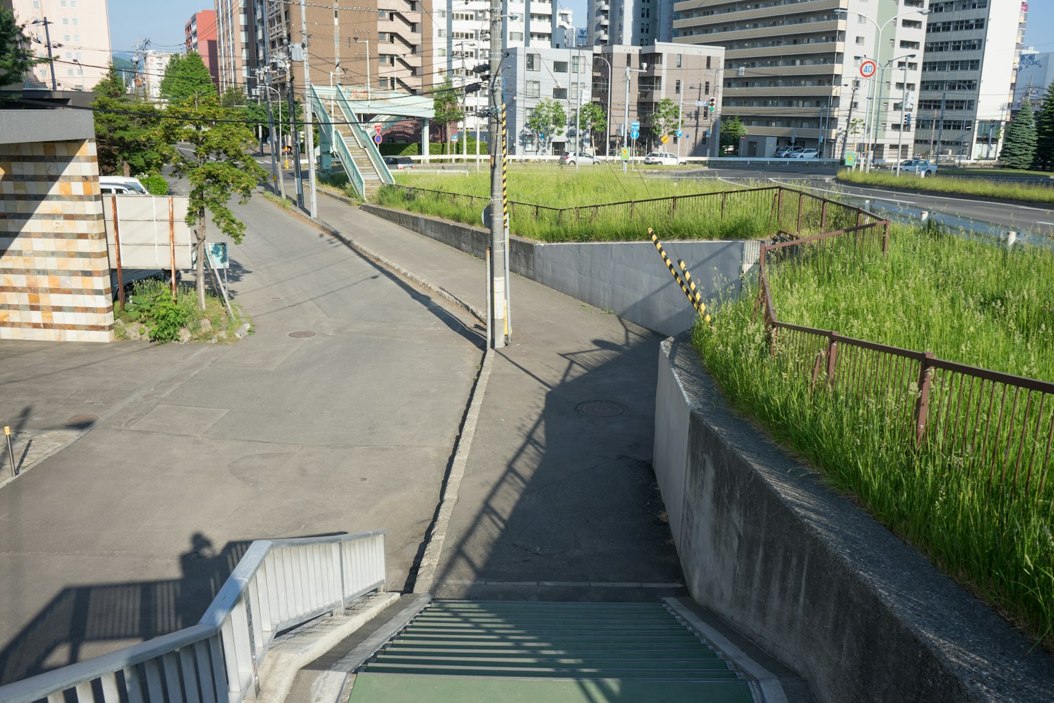 Chemin urbain avec une zone de gazon vert et des bâtiments