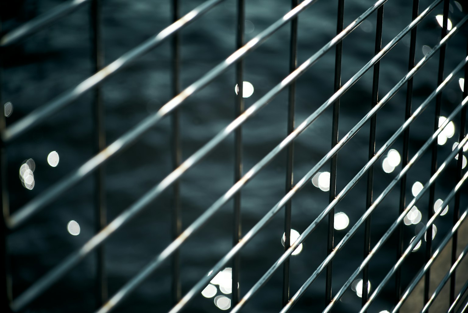 Grille métallique réfléchissant la lumière sur la surface de l'eau