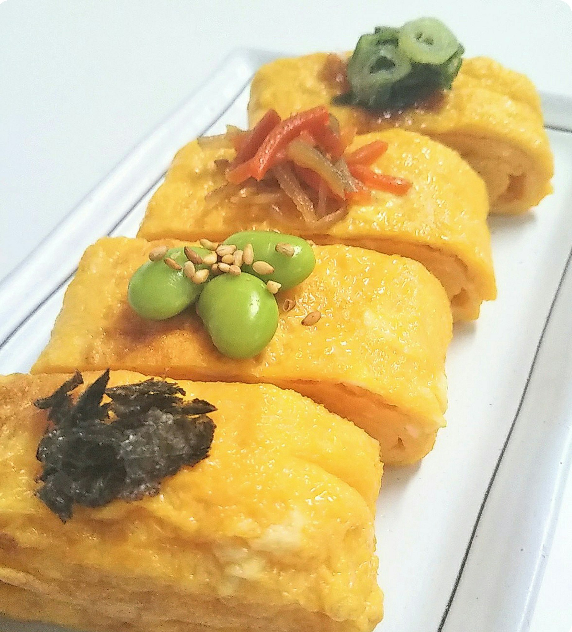 出汁巻き卵に枝豆と刻み海苔、彩り野菜をのせた一皿