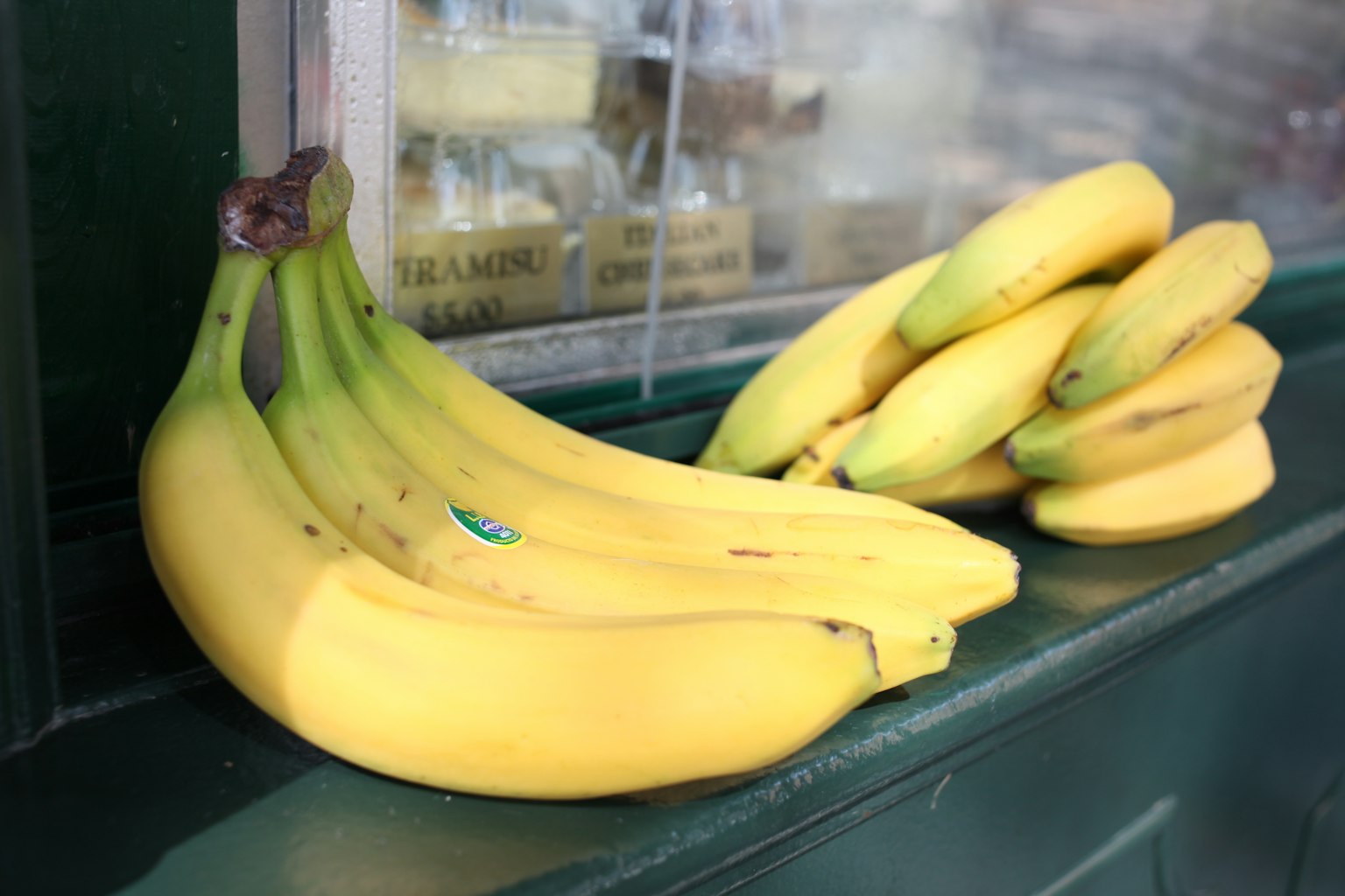 Seikat pisang matang diletakkan di atas meja hijau