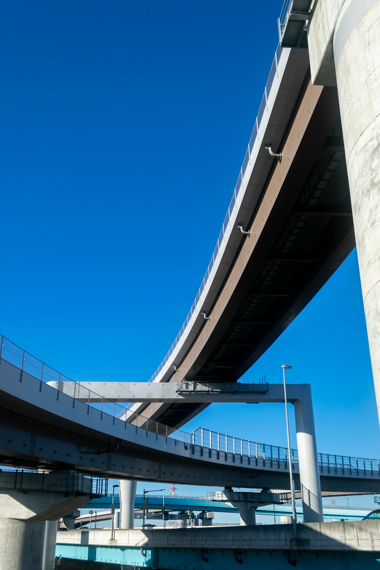Struktur jembatan tinggi yang kompleks di bawah langit biru yang cerah