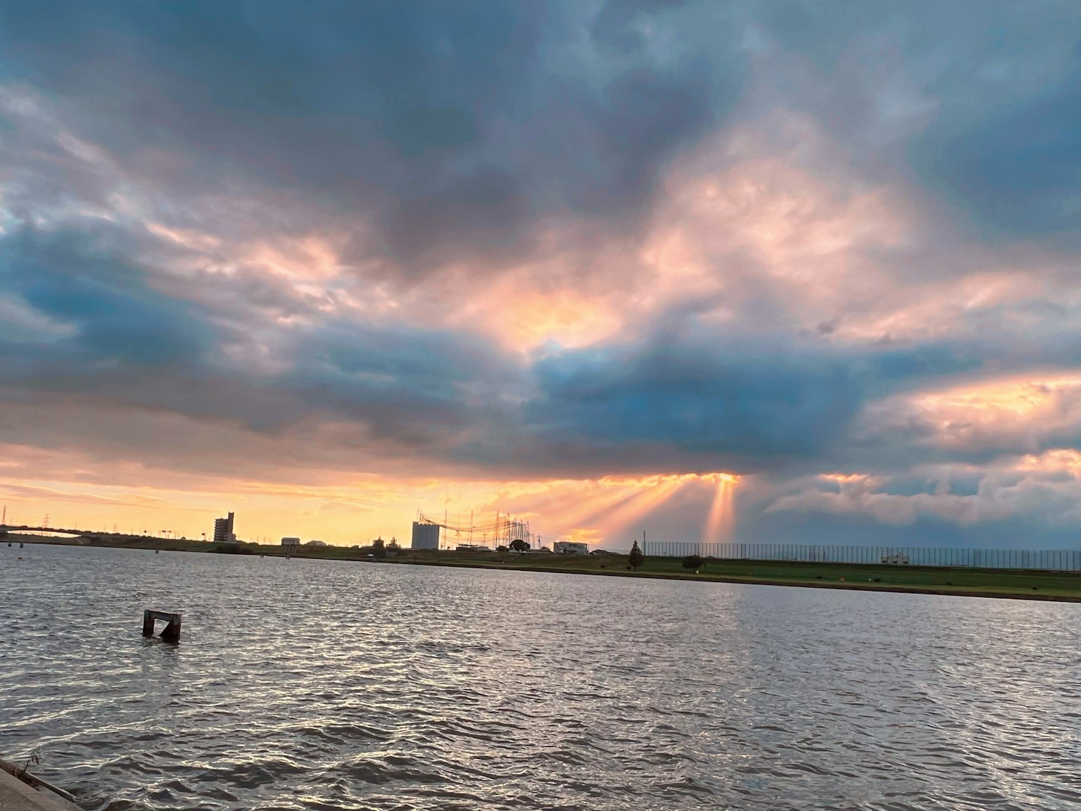 Vista escénica del cielo al atardecer sobre el agua con edificios a lo lejos
