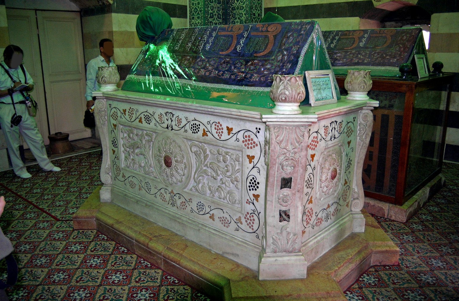 Interior bersejarah dengan makam yang dihiasi hiasan hijau